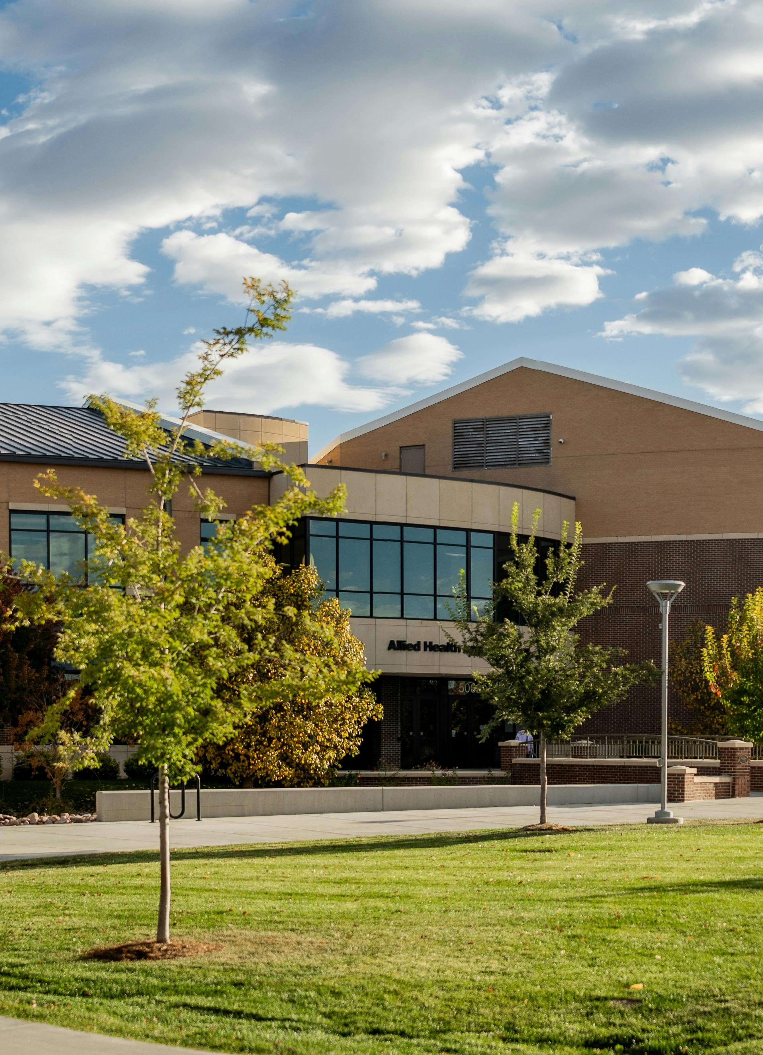 An Aims Nurse Aide instructor helps a student position a patient in a lab setting.