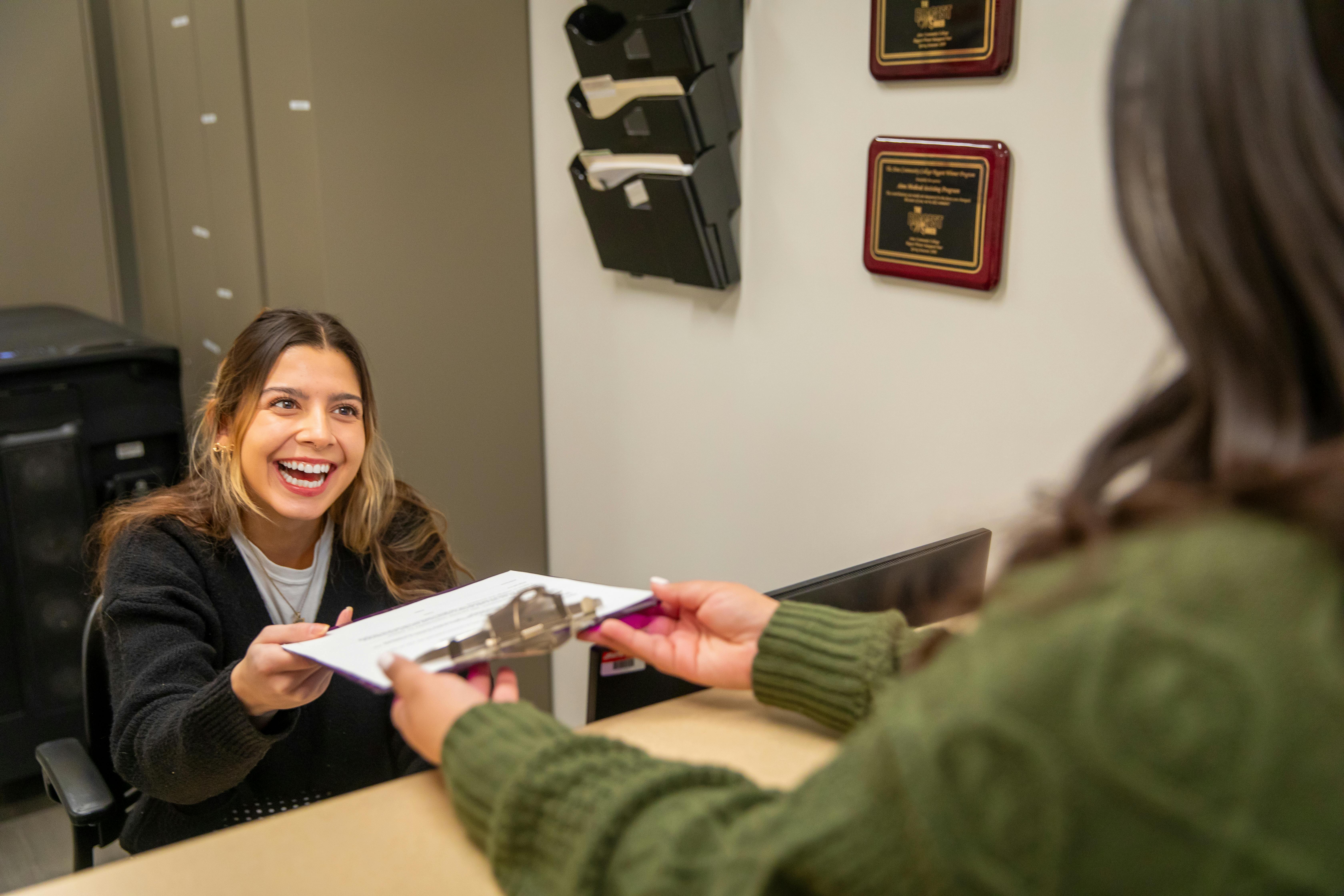 An Aims Medical Front Office student practicing patient intake in a simulated medical office setting