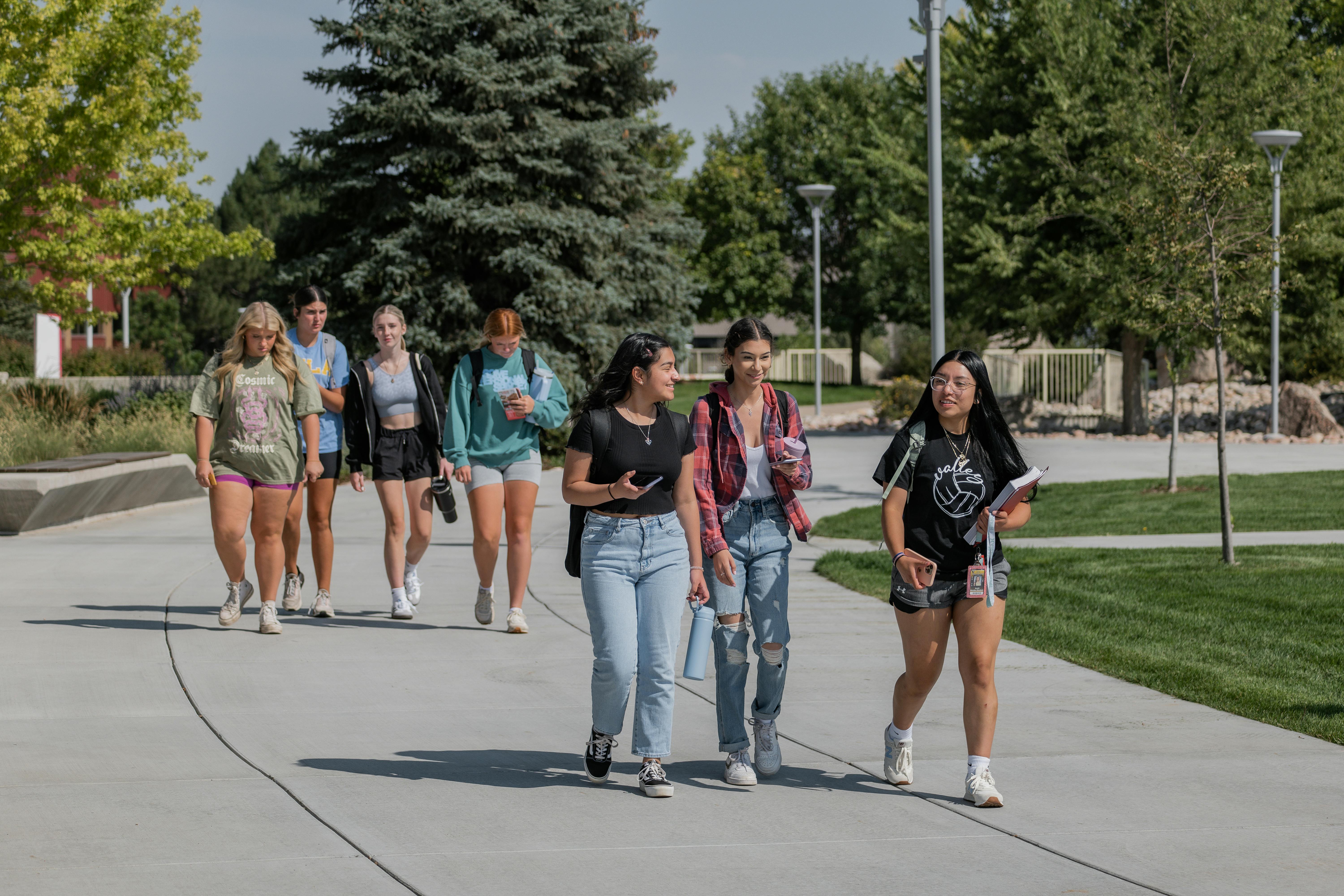 group of seven students walking together through campus