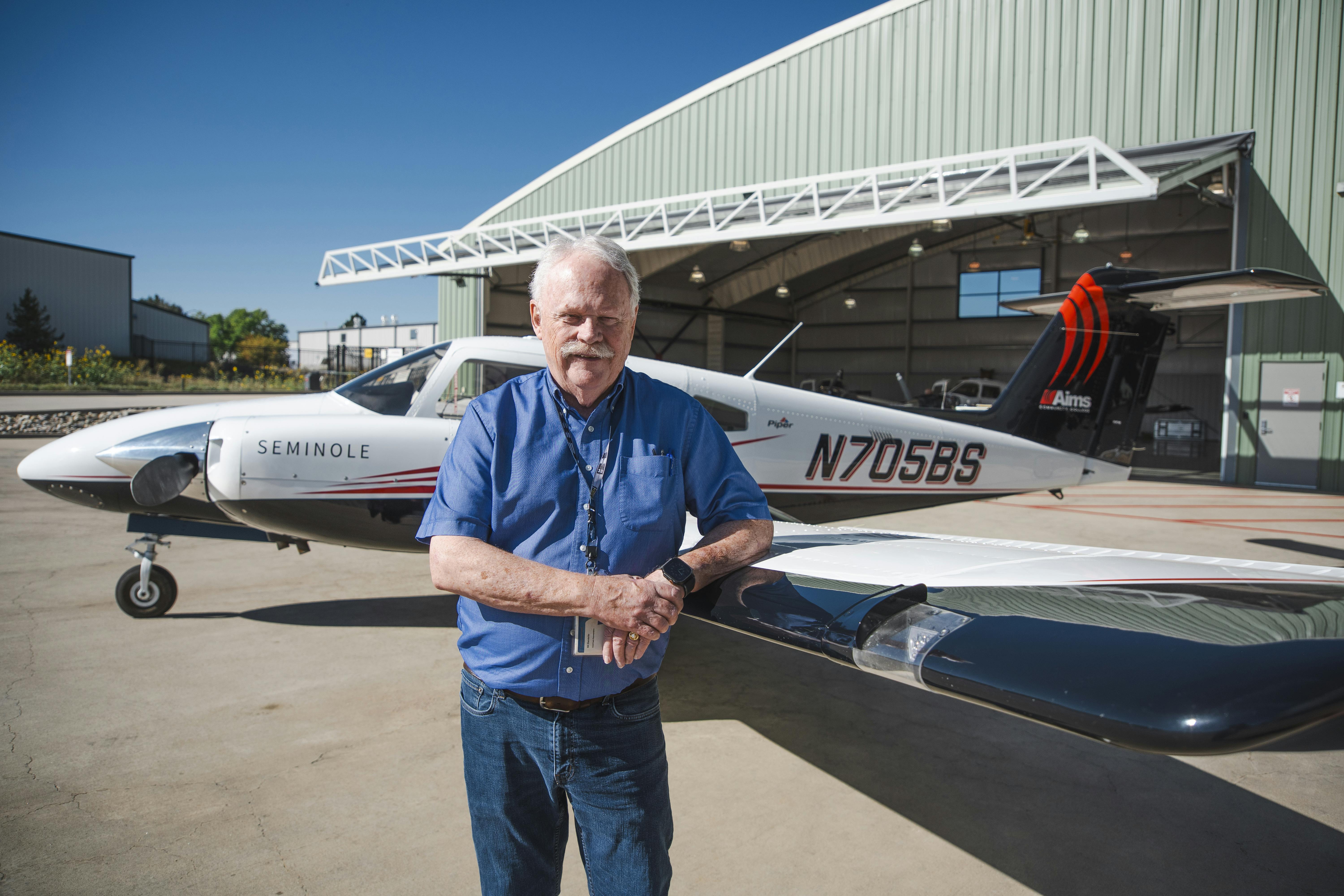 Aims Aviation instructor William Standefer standing with an aircraft at the Aims Flight Training Center