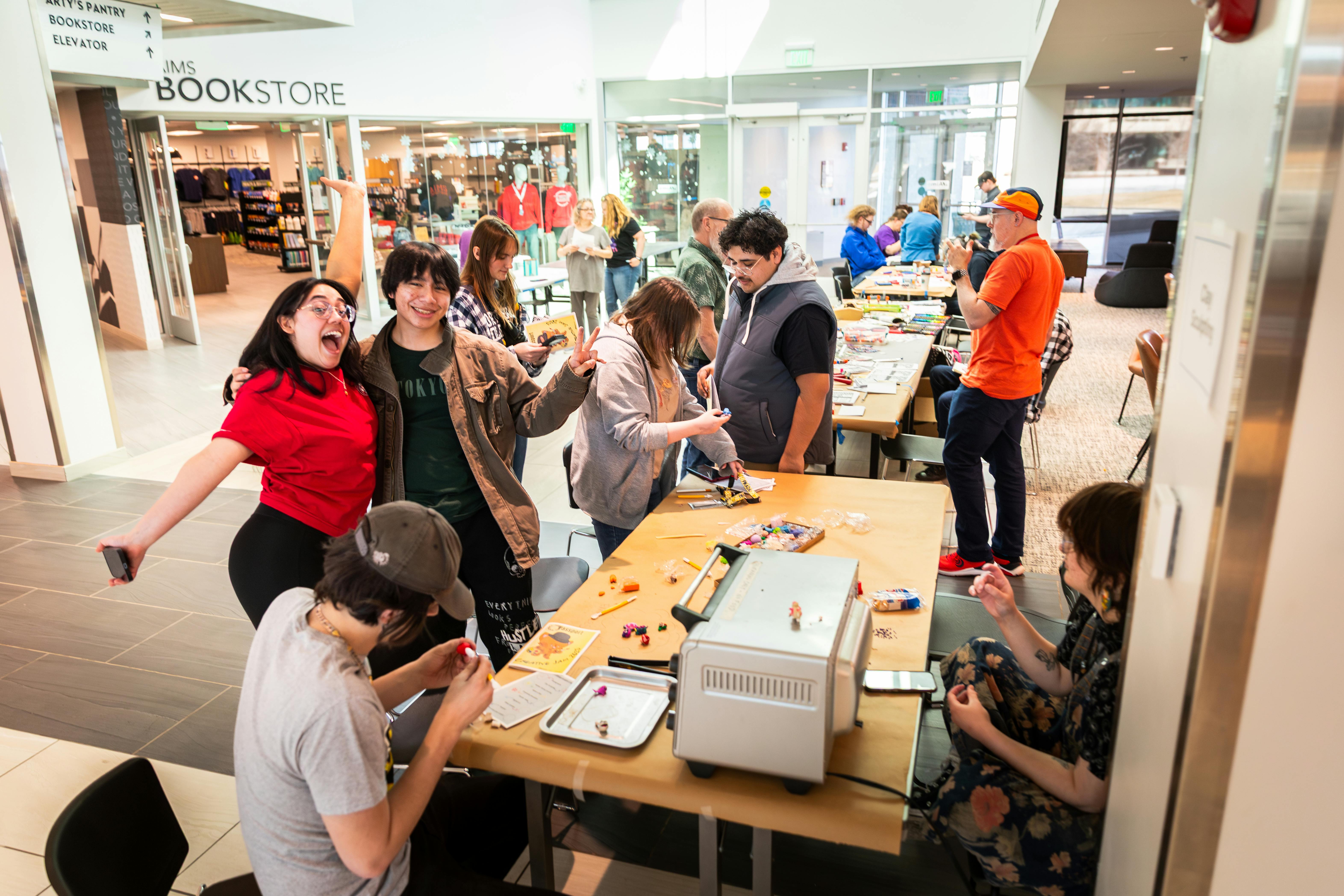 group of students around a large table working on a project together