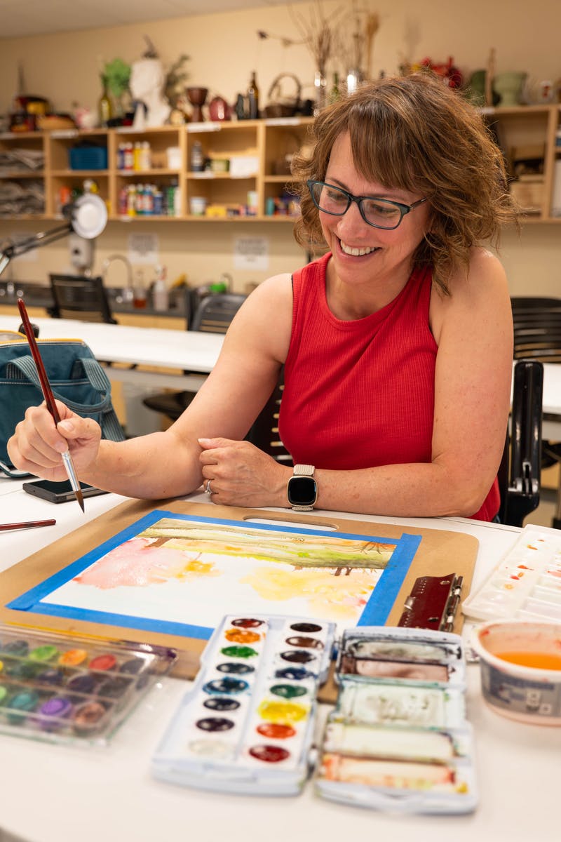 Aims student in an art class