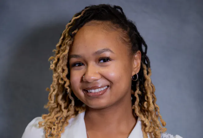 Admissions Counselor, Da'Najah Atterberry, facing camera with blue background.