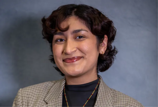 Admissions Counselor, Jahedy Rojas, facing camera with blue background.