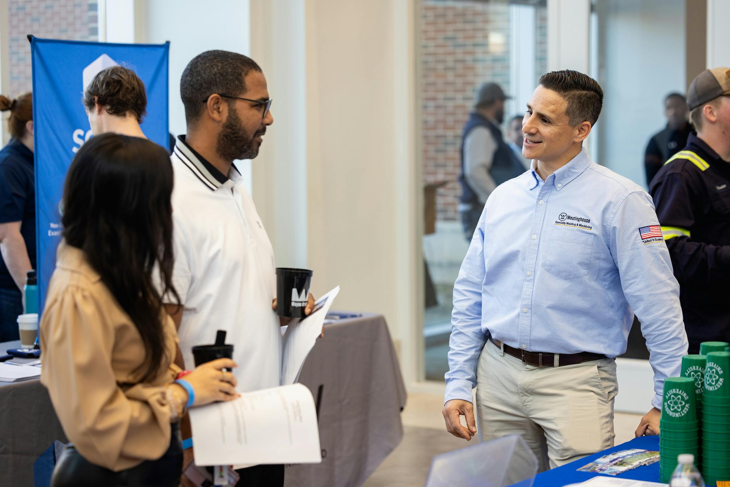 Employer intently engaged in conversation with two students