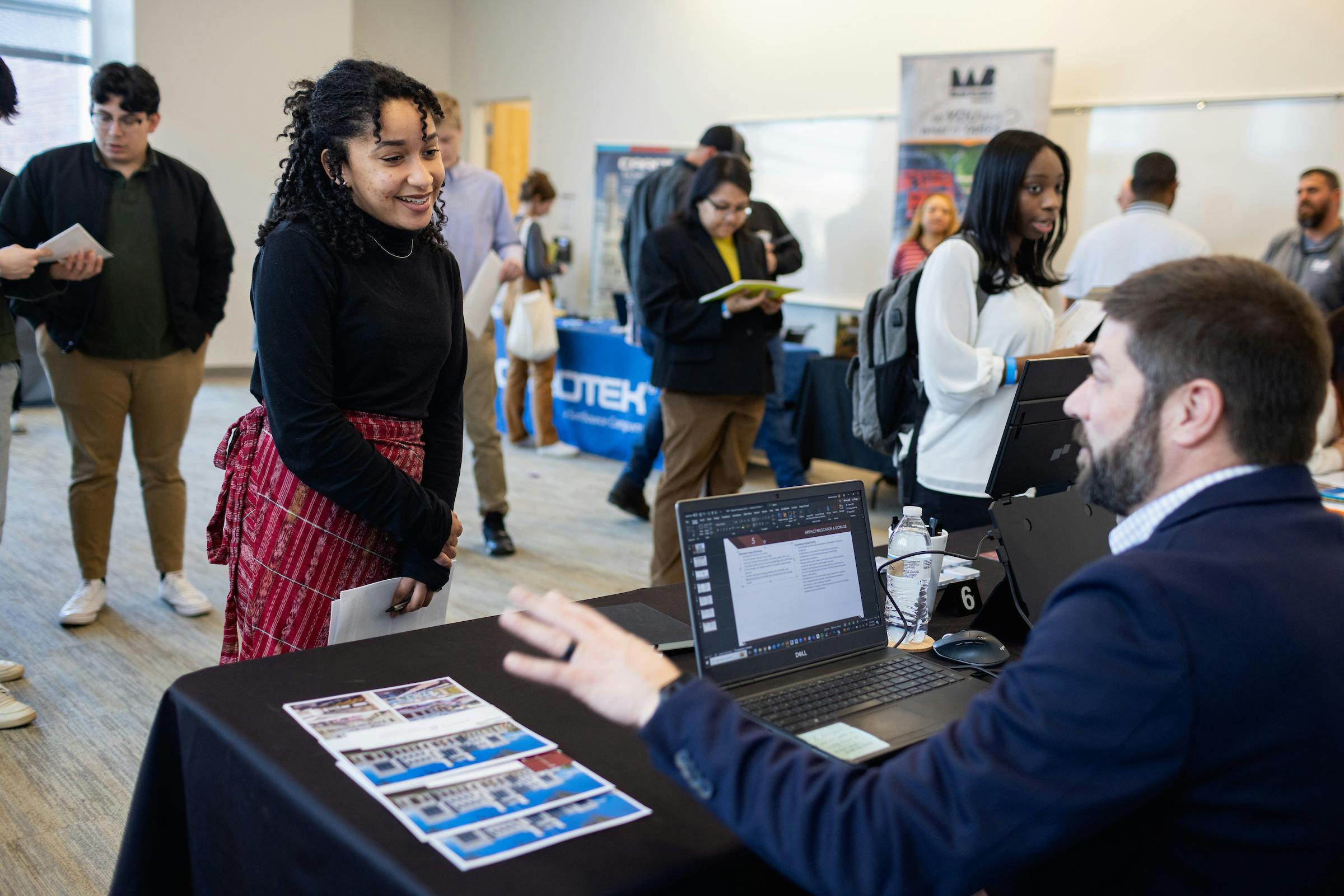 Smiling student approaches career recruiter