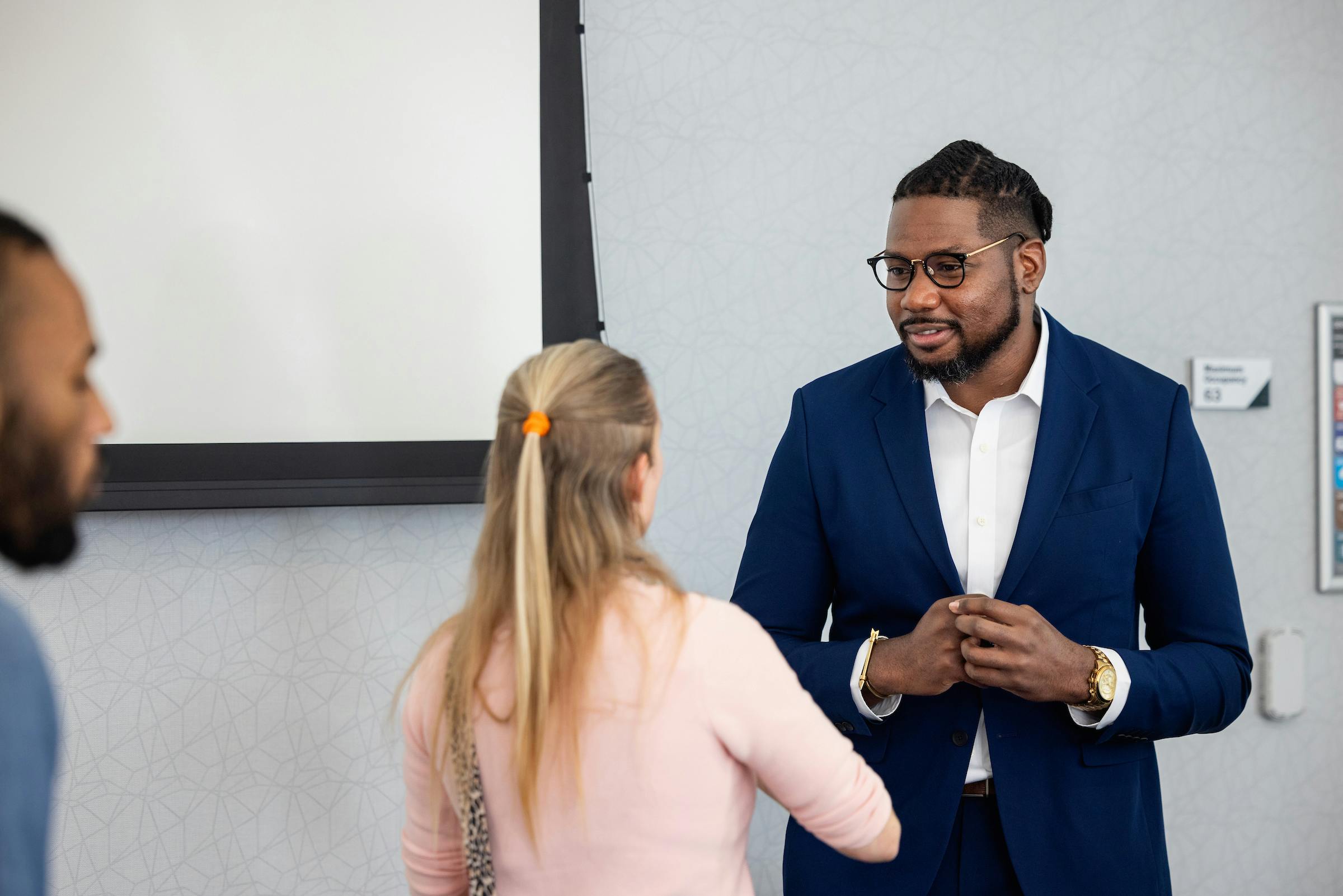 Two people in professional attire, talking to one another