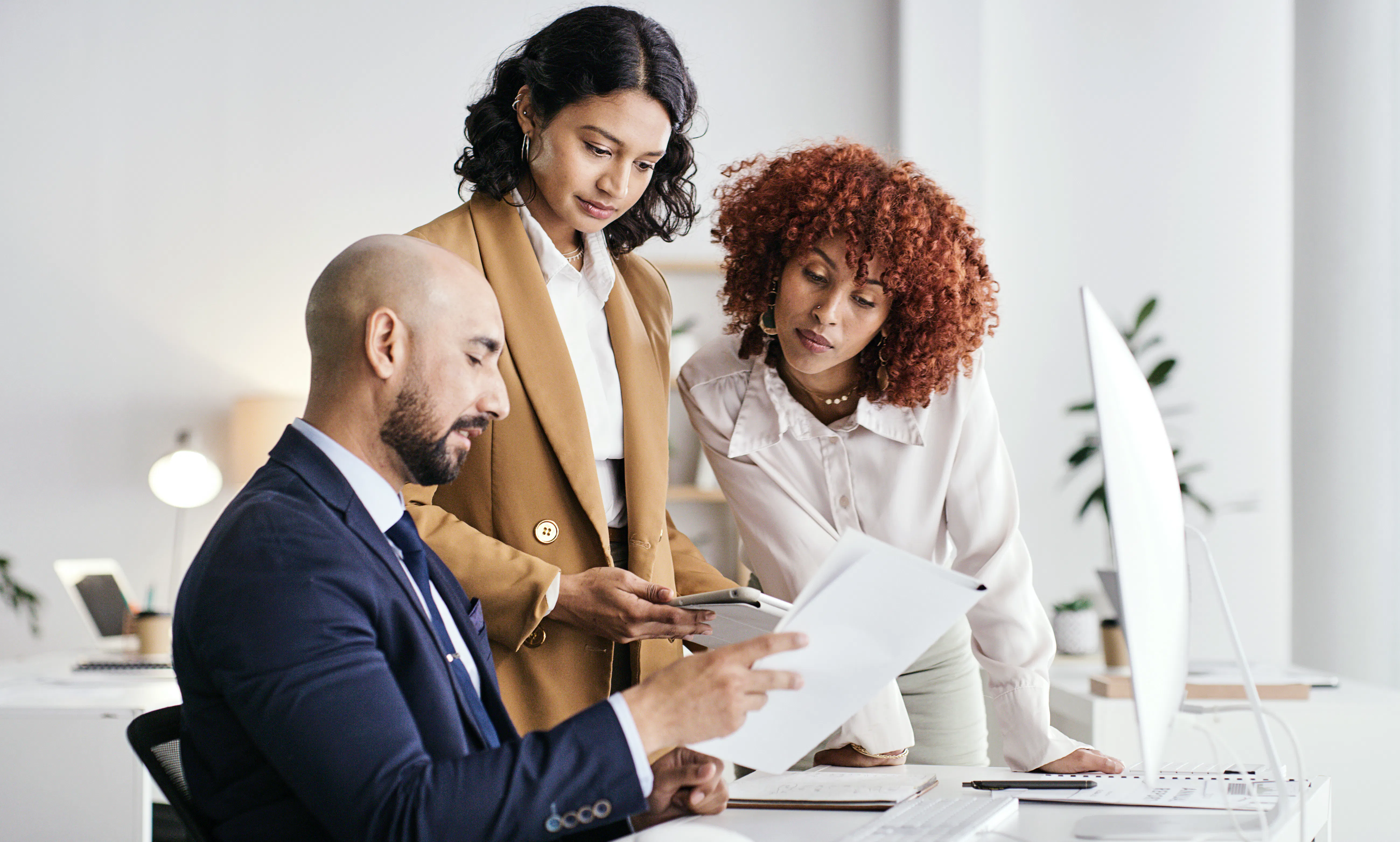 A group of tax professionals reviews financial data on a computer screen.