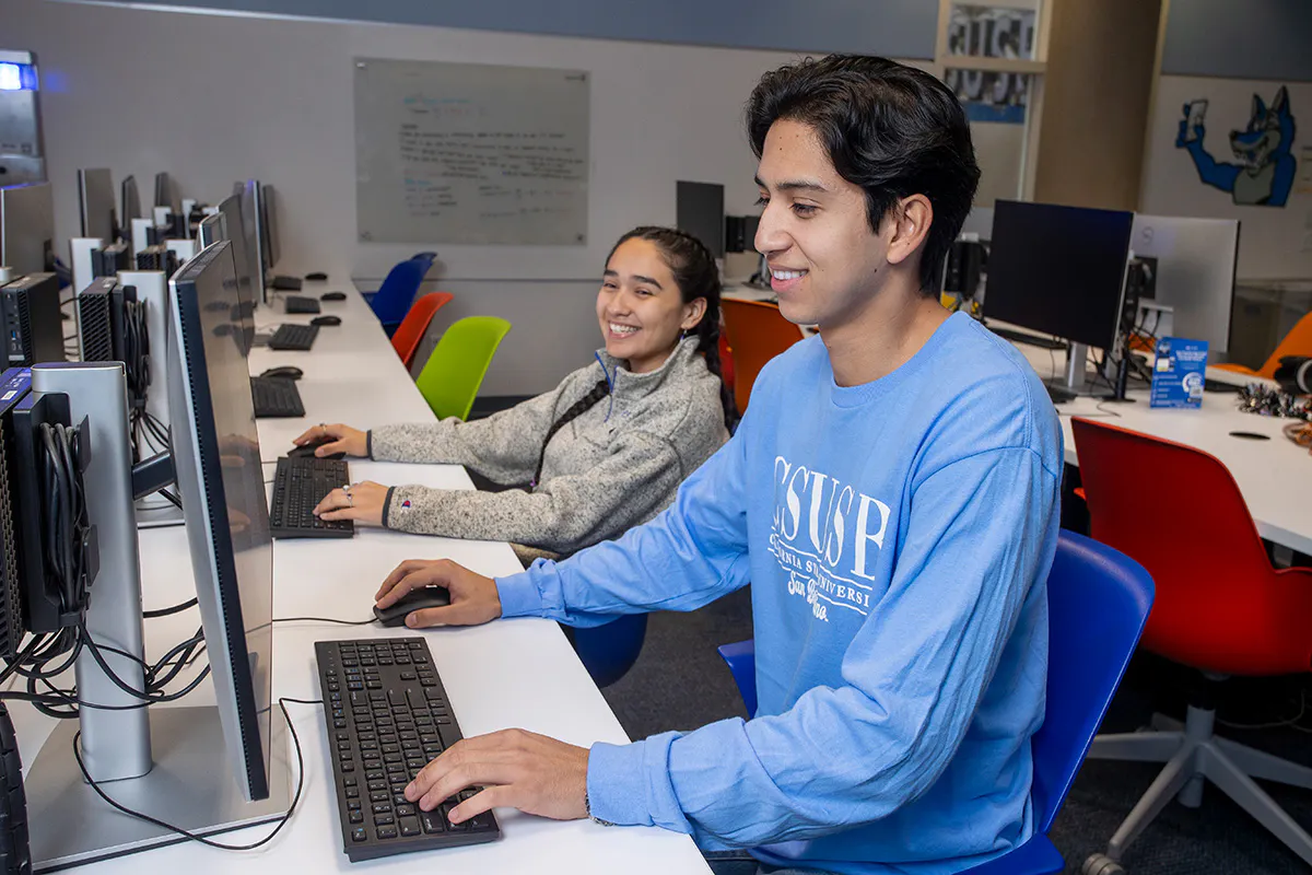 A male and female student working at computers