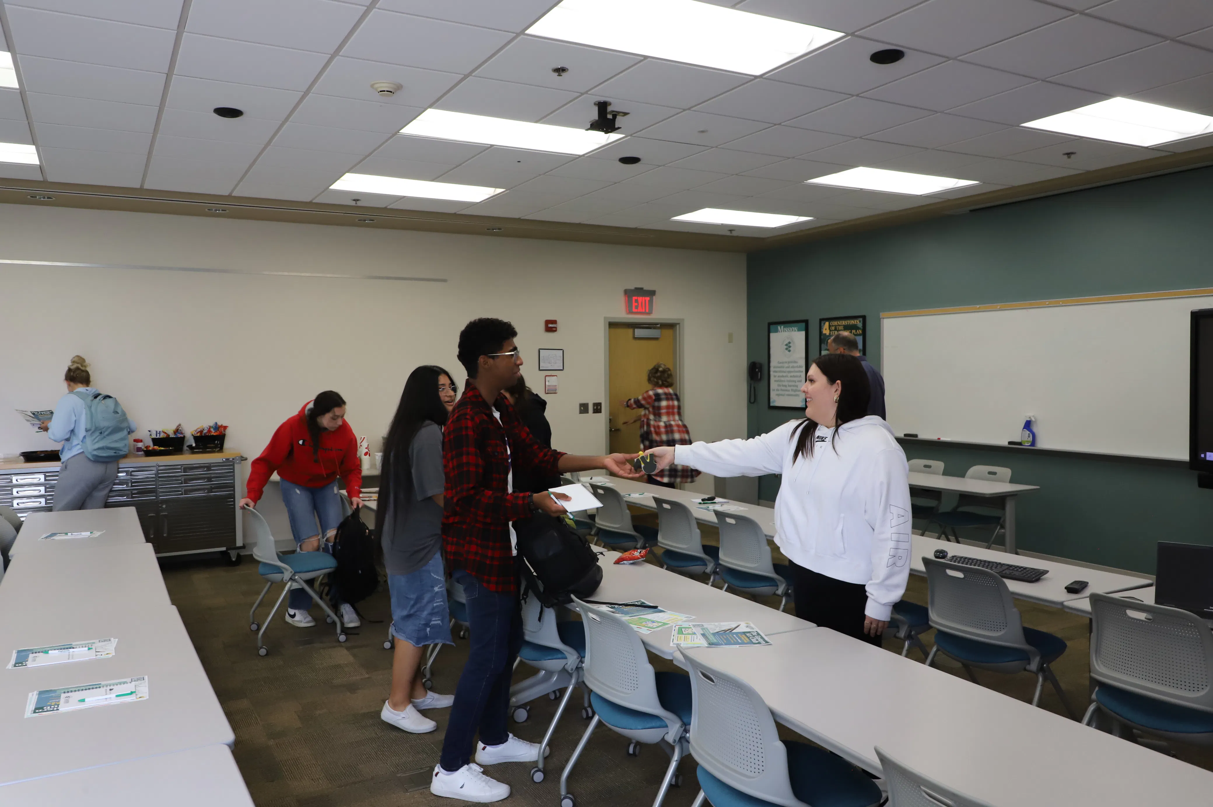 Photo of students interacting with others in the background.
