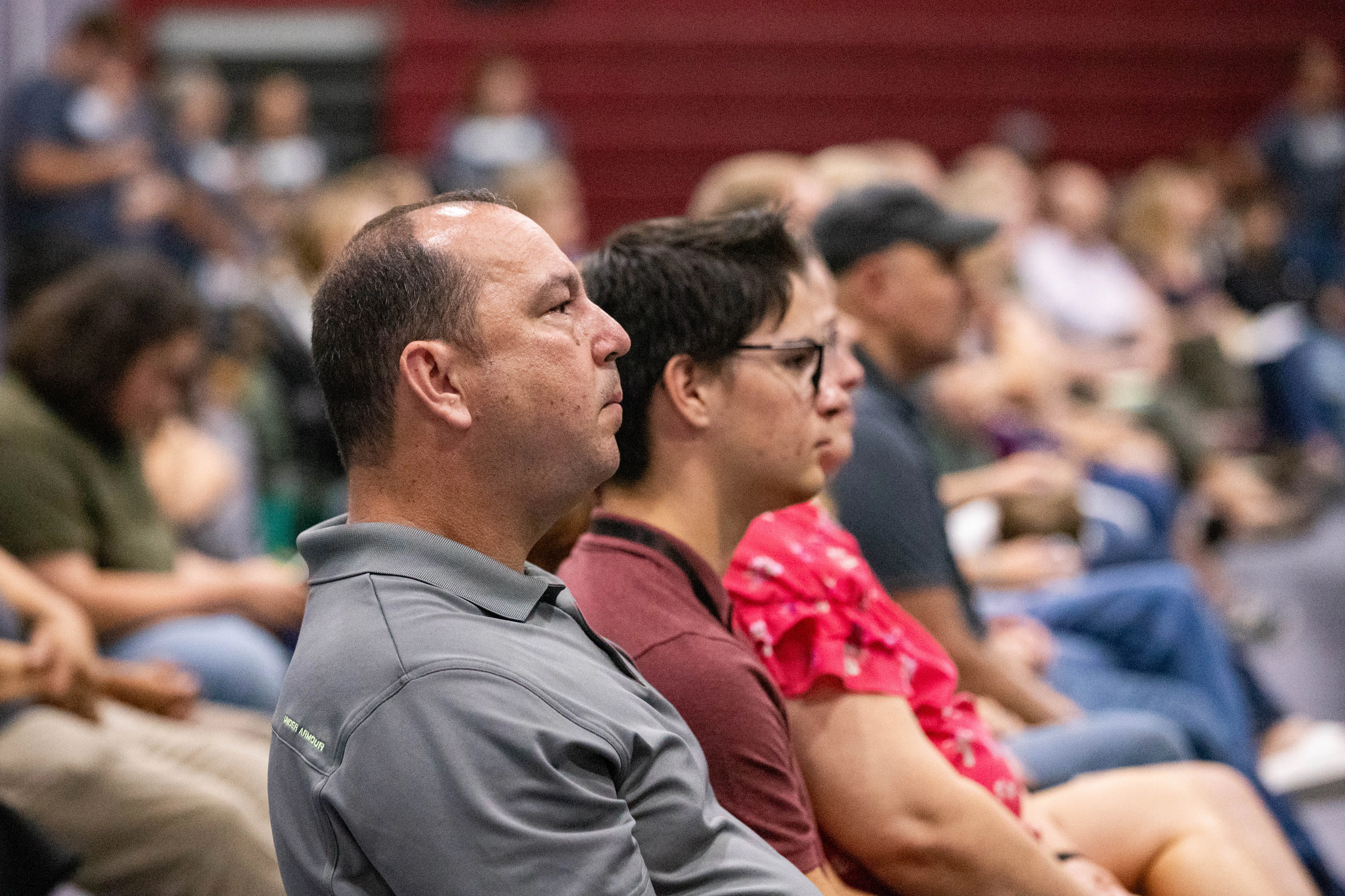 Parents and Students sitting in chair listening to a speaker talk