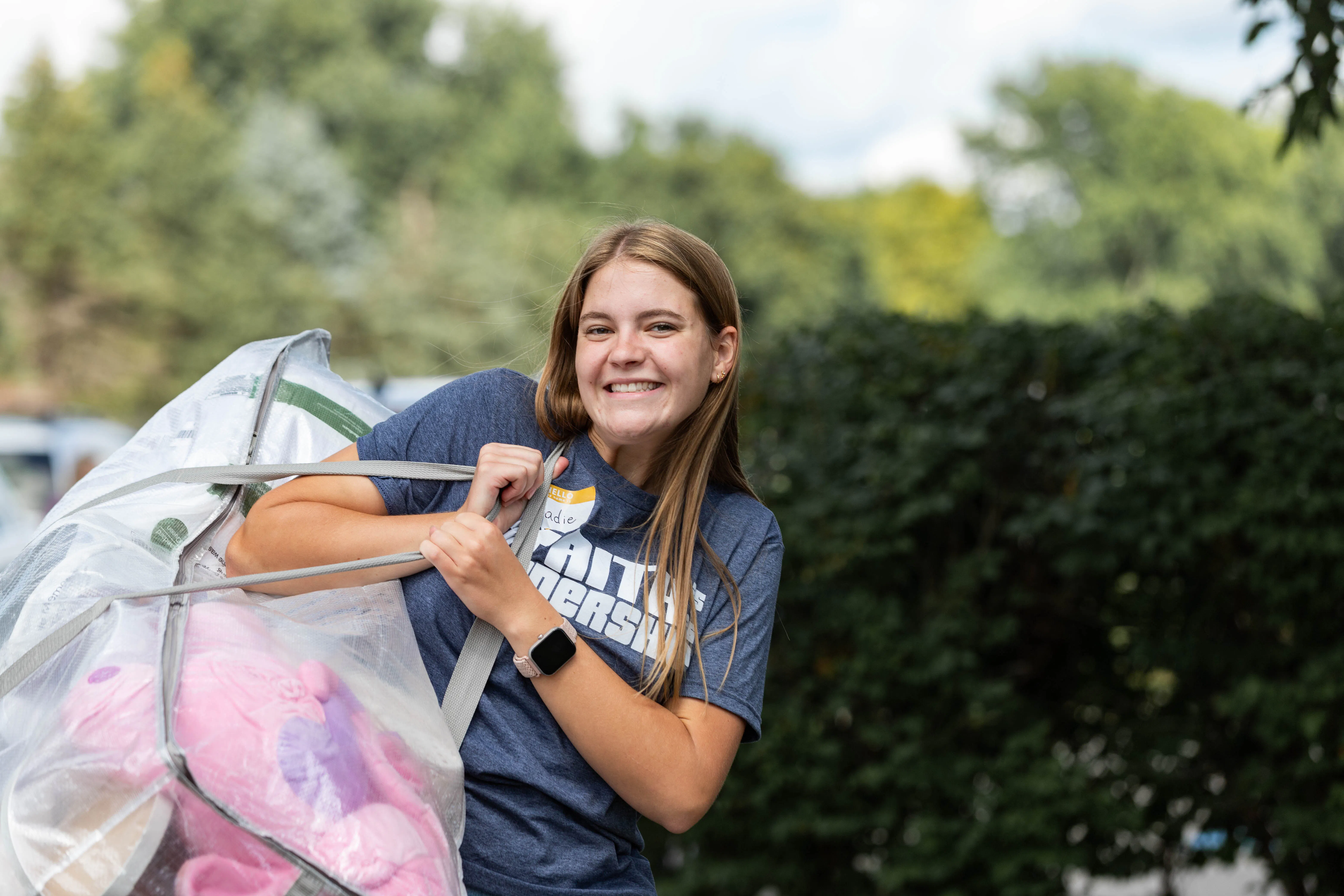 Faith student carrying luggage into the dorms