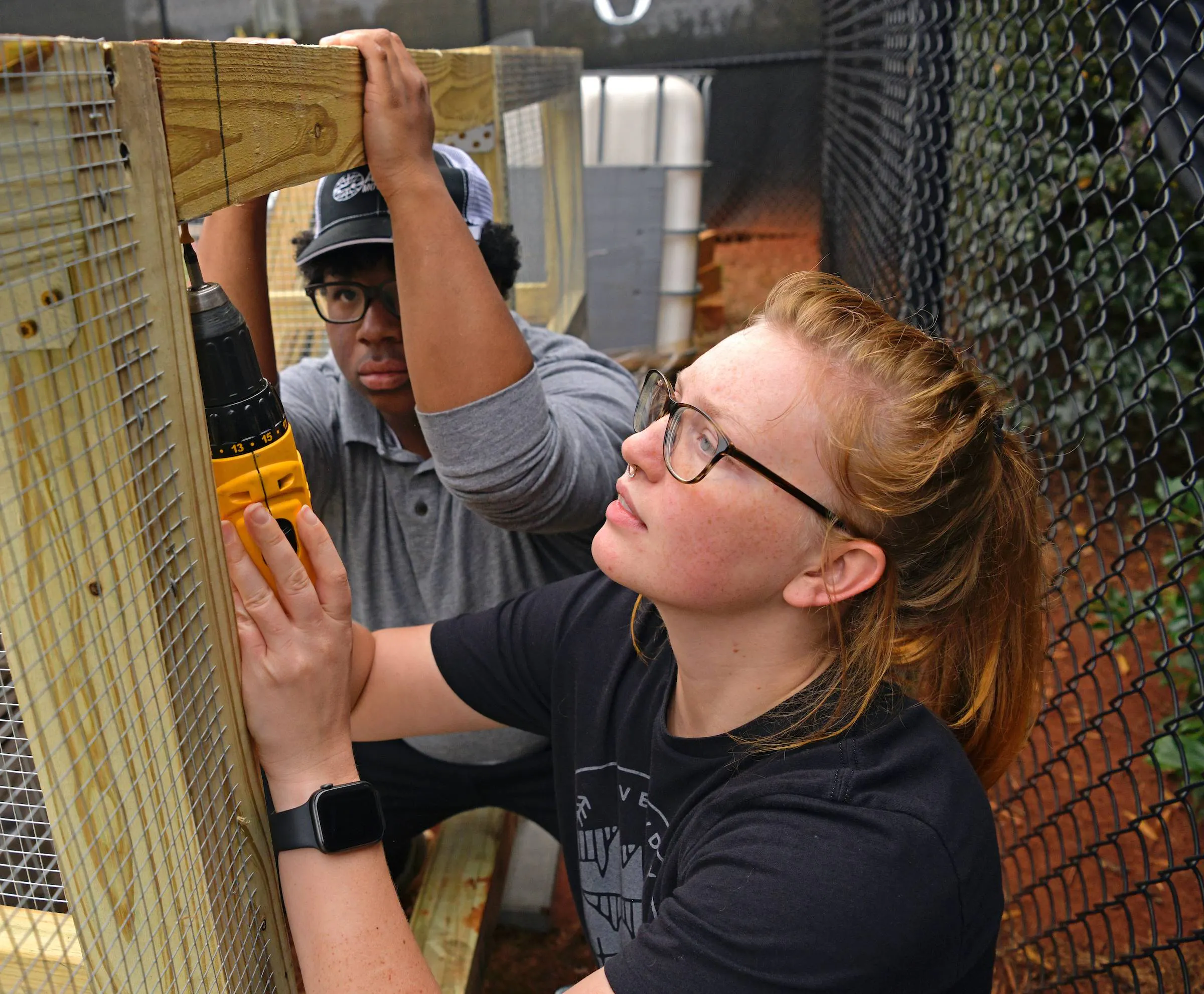 female student drilling into a wood construction project