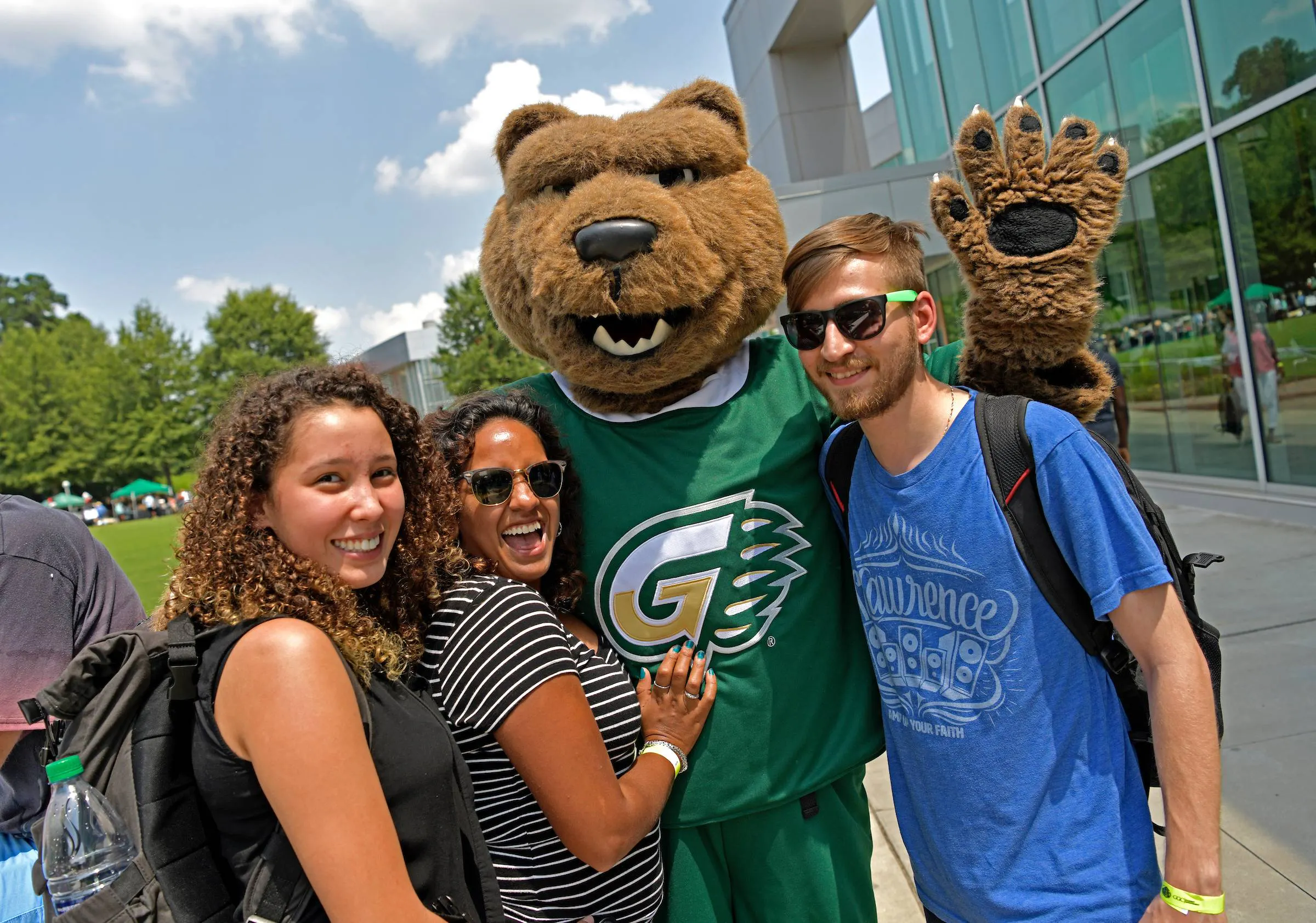 Grizzly Bear mascot posing with three students