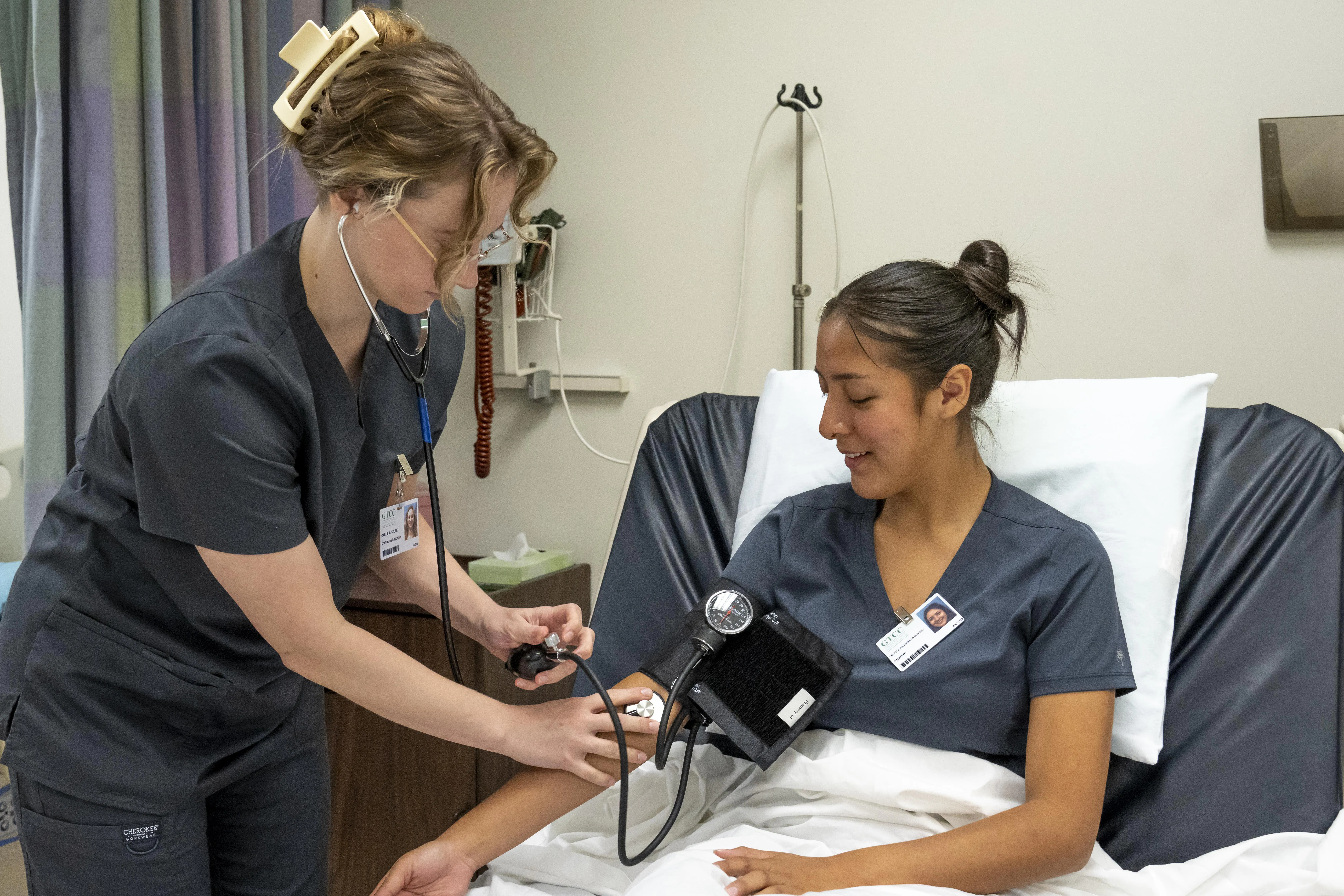 Nursing student taking pulse of another nursing student