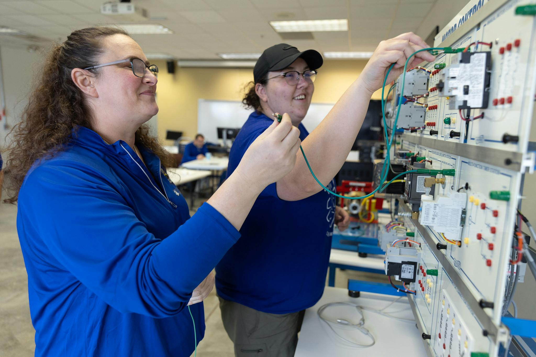 A female student learns from their instructor about industrial technology