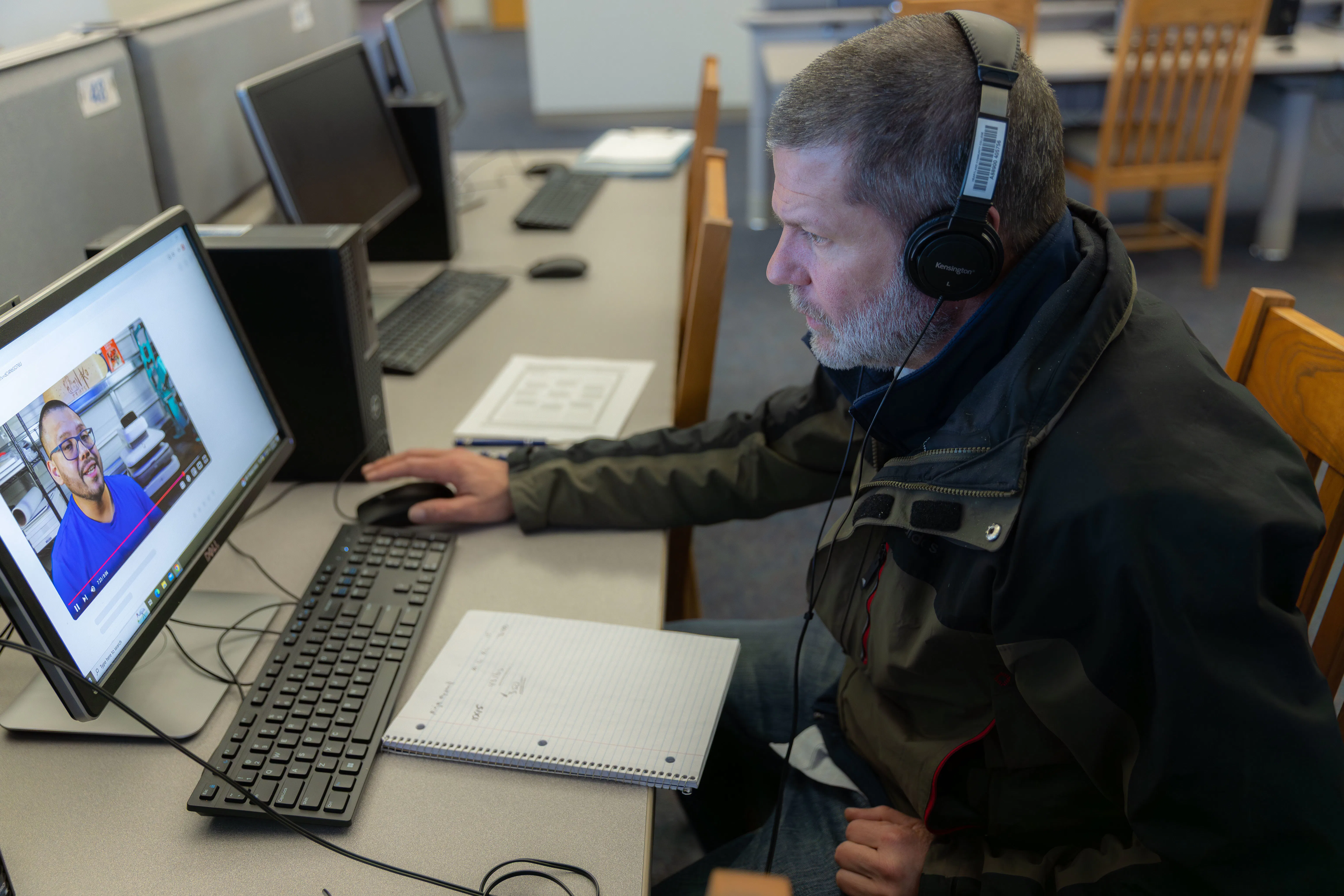 Image of student working at a computer wearing headphones