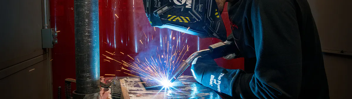 Bright sparks fly as a welding student joints two pieces of steel.
