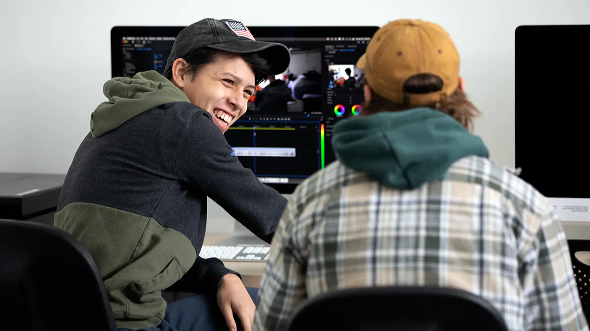 Film students laughing and collaborating on a project in class.