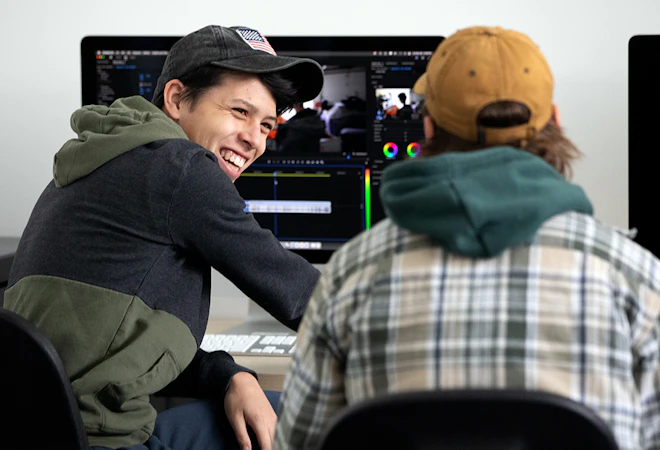 Film students laughing and collaborating on a project in class.