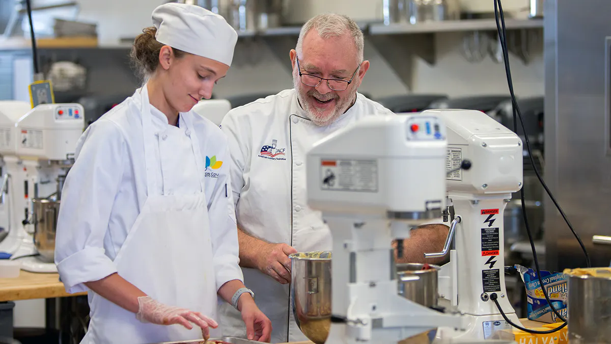 Student works with instructor in JCCC pastry lab.