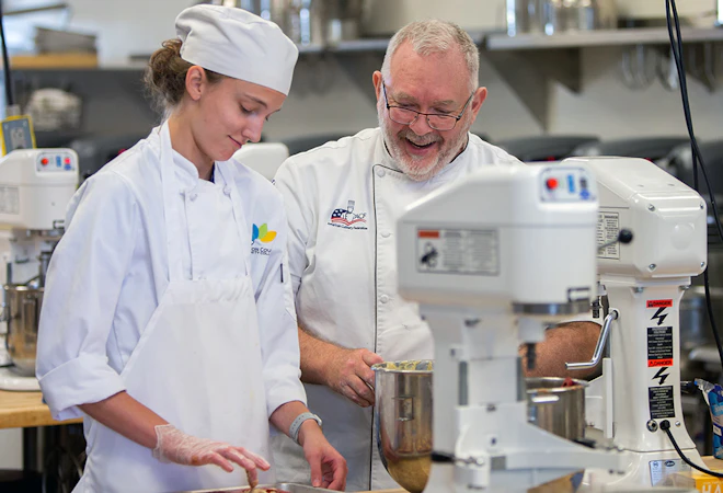 Student works with instructor in JCCC pastry lab.