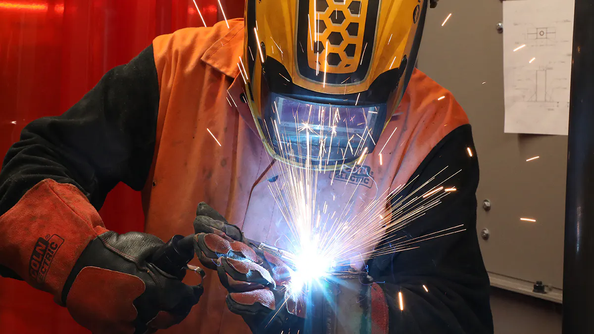 Sparks flying as a welding student works in one of JCCC's many welding bays.