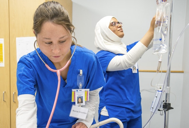 Two nursing students performing tasks in a clinic
