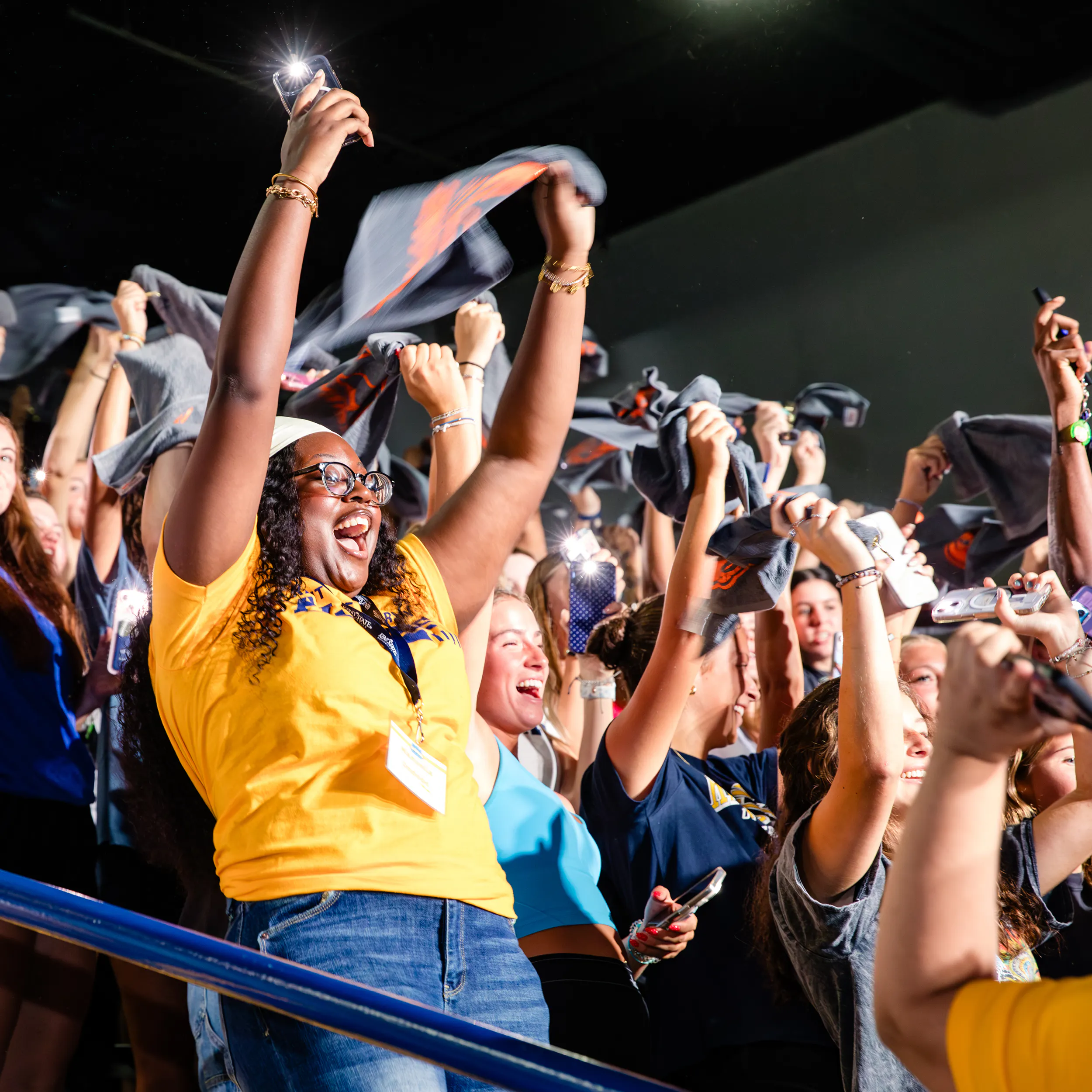 Kent State students in stands cheering and waving towels.
