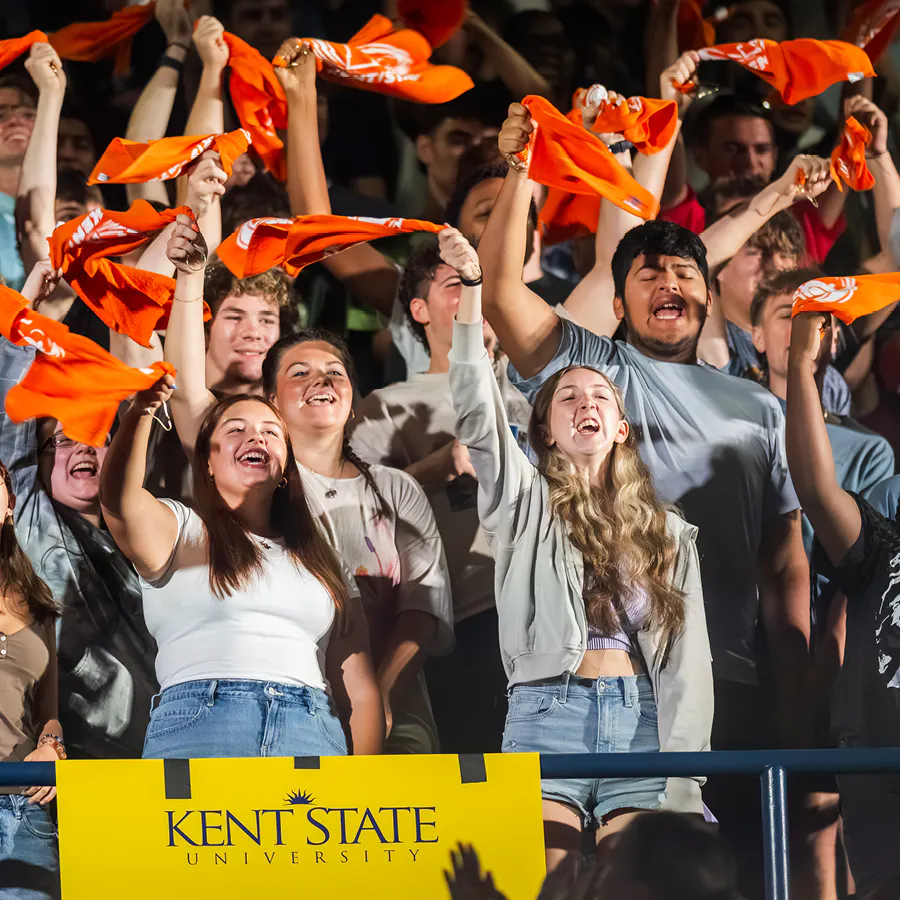 Various female and male students dressed casually cheering, smiling, and waving orange towels for the College of Aeronautics and Engineering. 