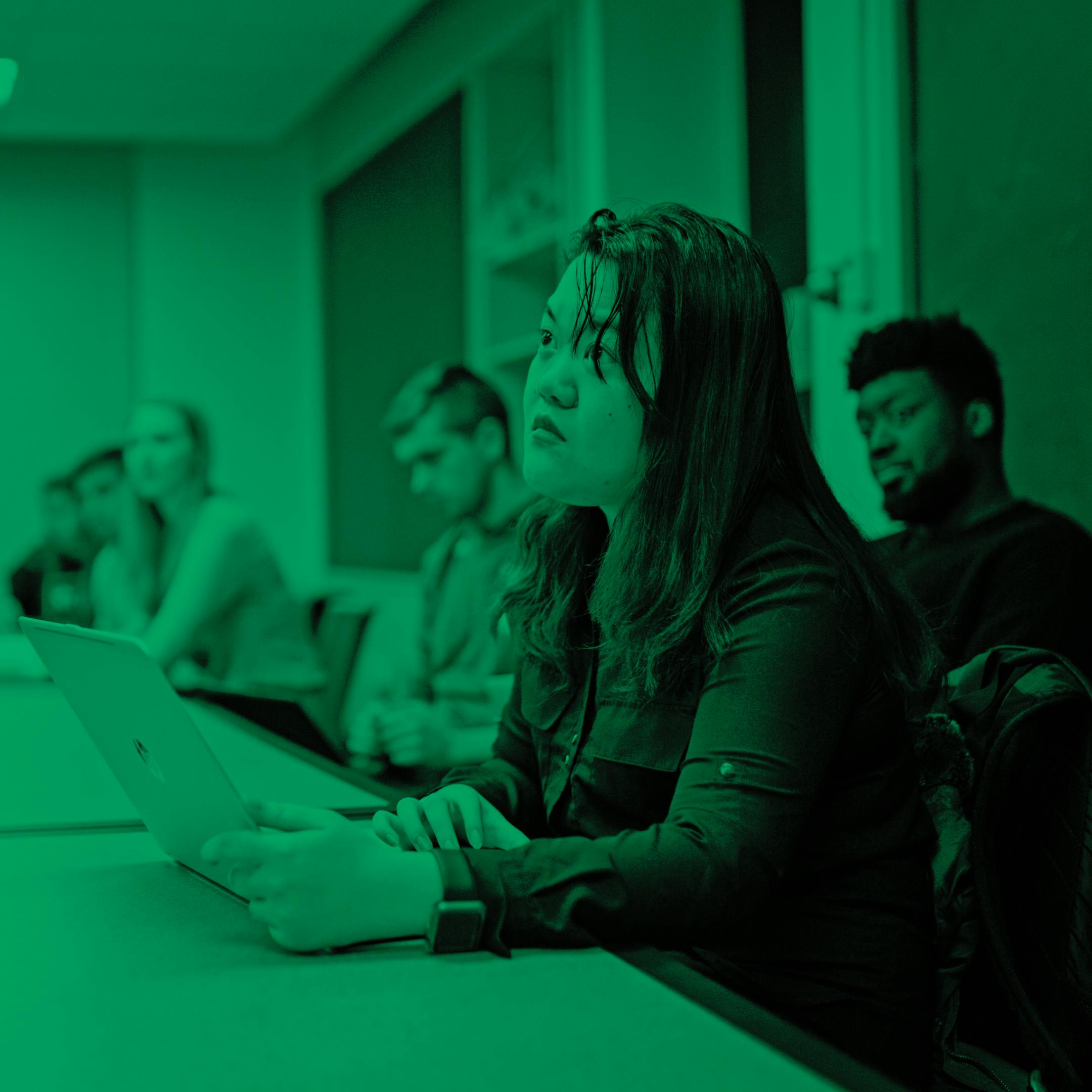 students smiling in listening to professor