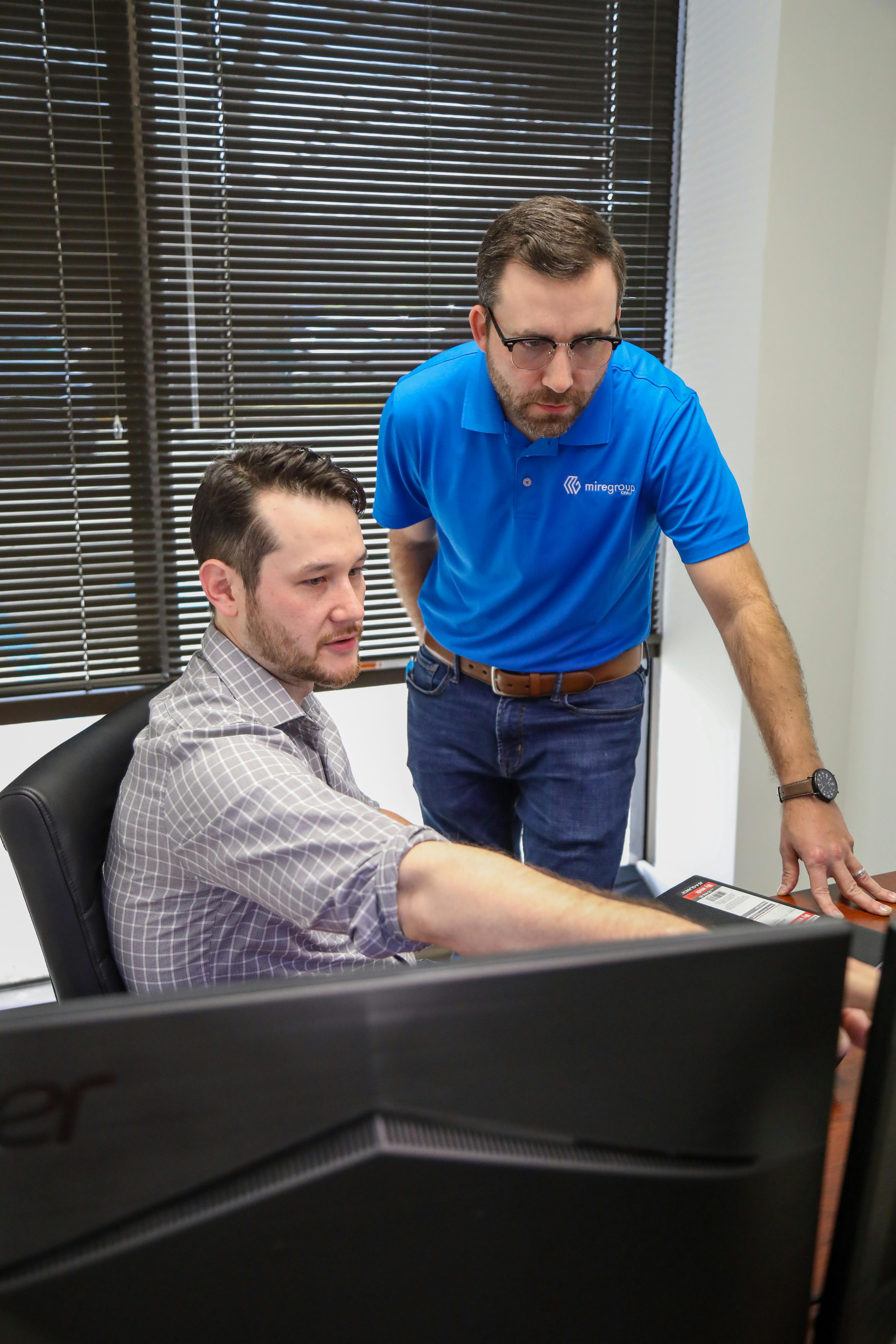 Alumni Jonathan Kim reviews reports with a colleague.