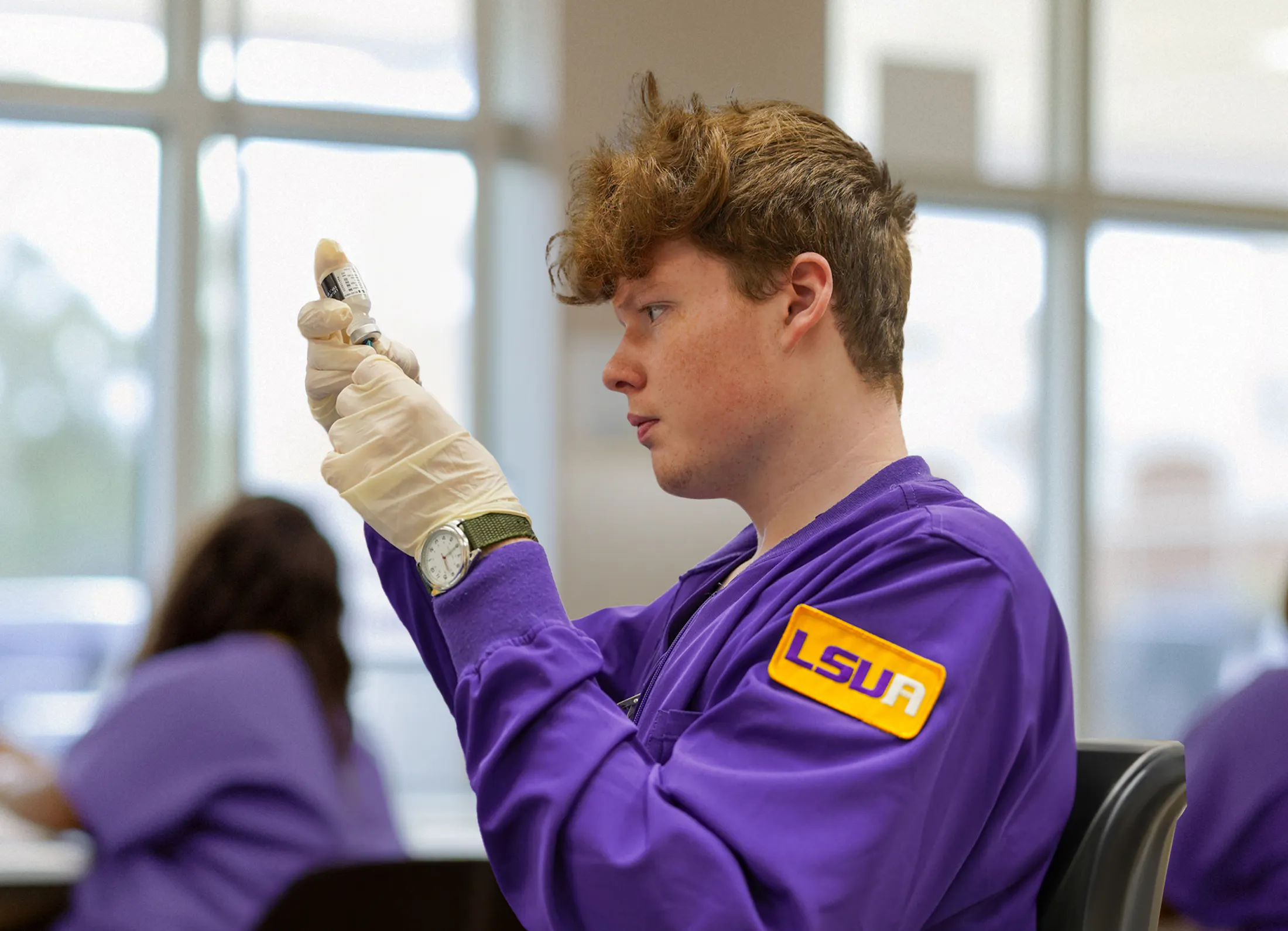 An LSUA Nursing Student working with a syringe and medicine bottle.