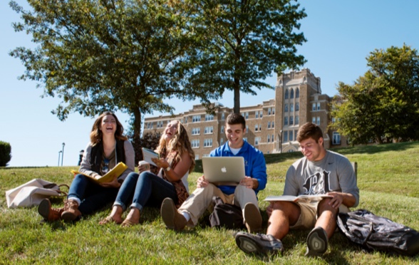 Four students sitting on campus lawn
