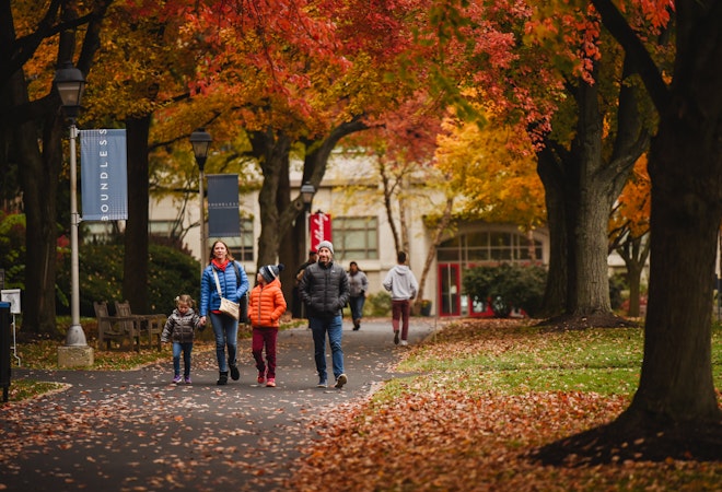 This is a picture of a group walking through campus during fall.