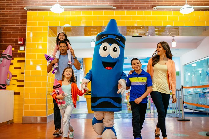 A family walking with a blue crayon mascot at the crayola experience.