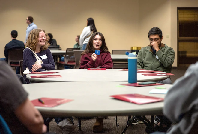 Students laughing around a table.