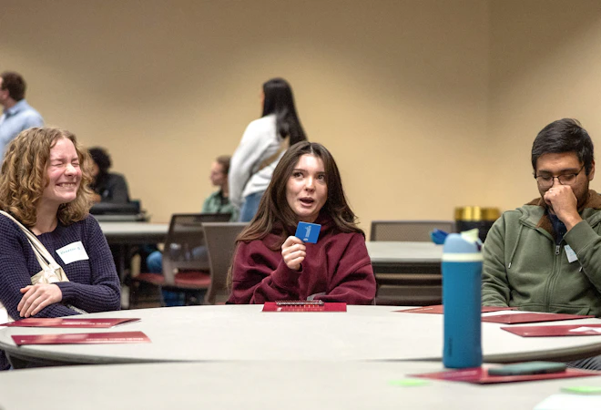 A group of students laughing around a table