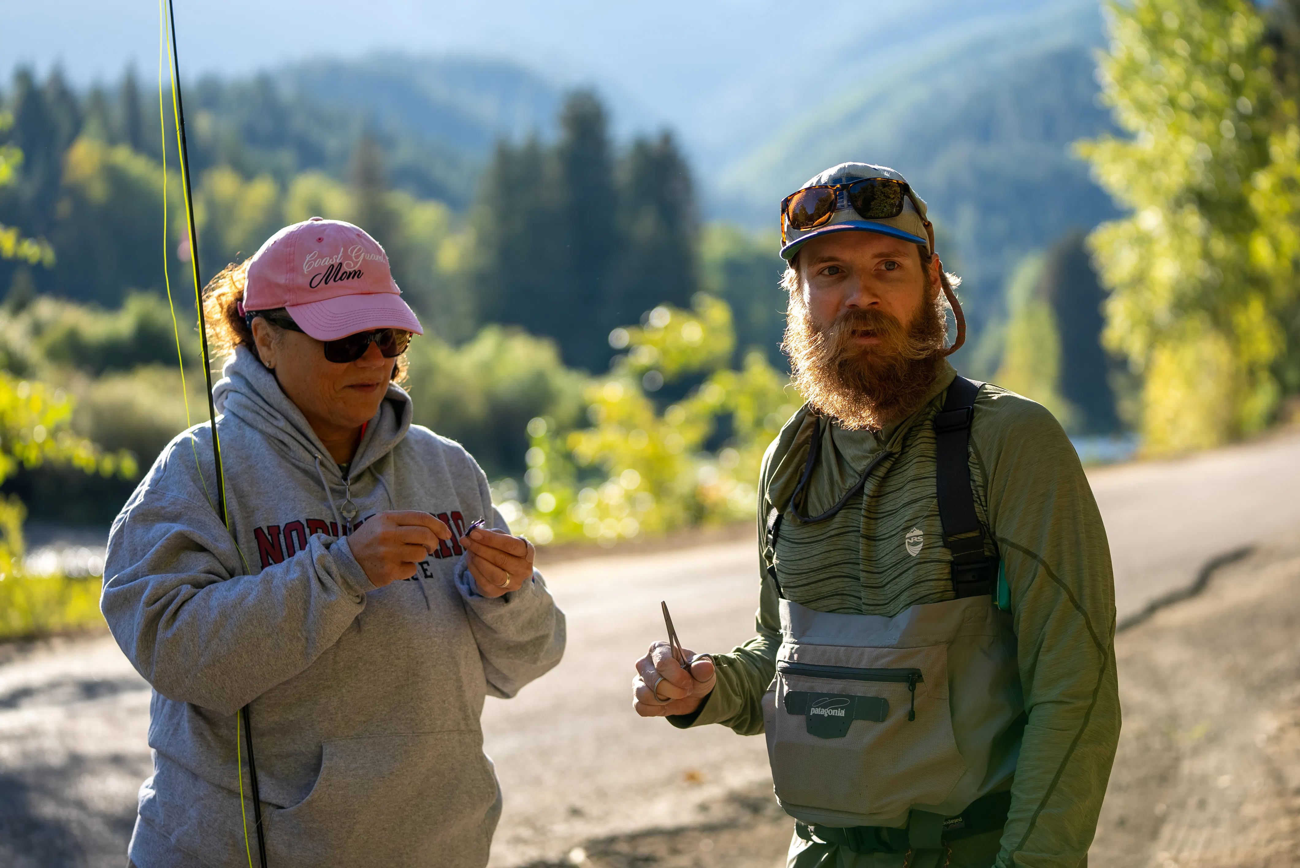 A student and teach preparing to fly fish on the river.