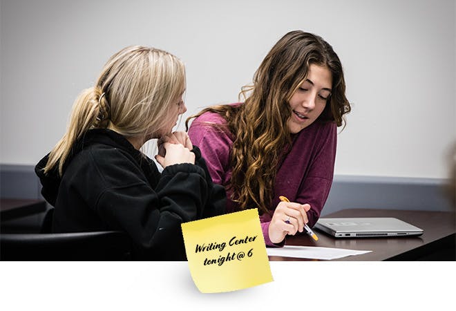 Two students work together on a project in Intro to Literature class.