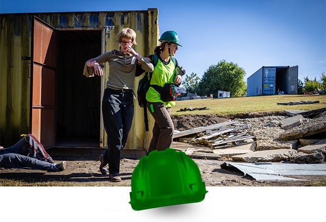 A student rescues another during a disaster training exercise.