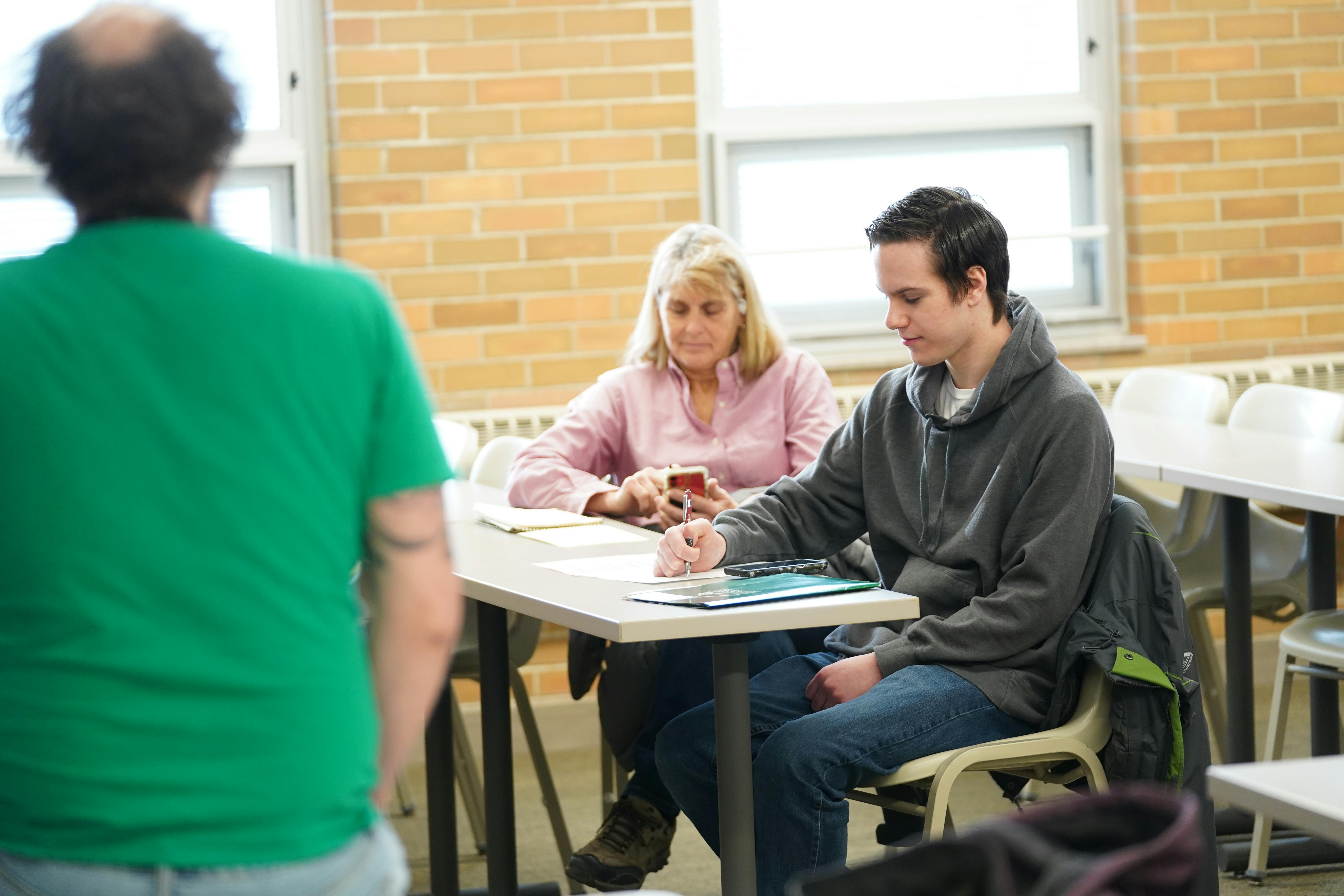 elm-pg-billboard-app Male Student in classroom with proud supporter