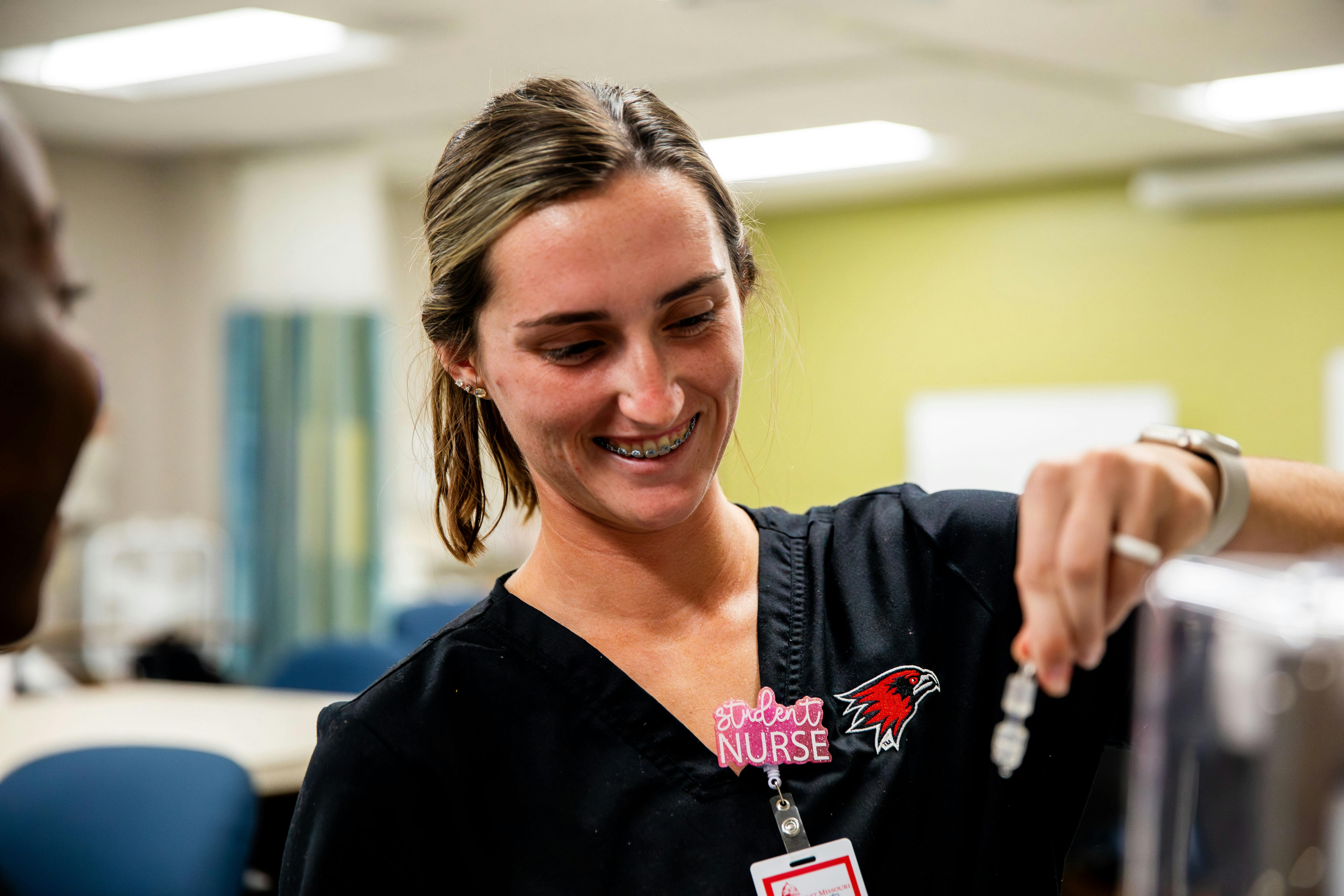 nursing student practicing giving an IV to a mannequin 