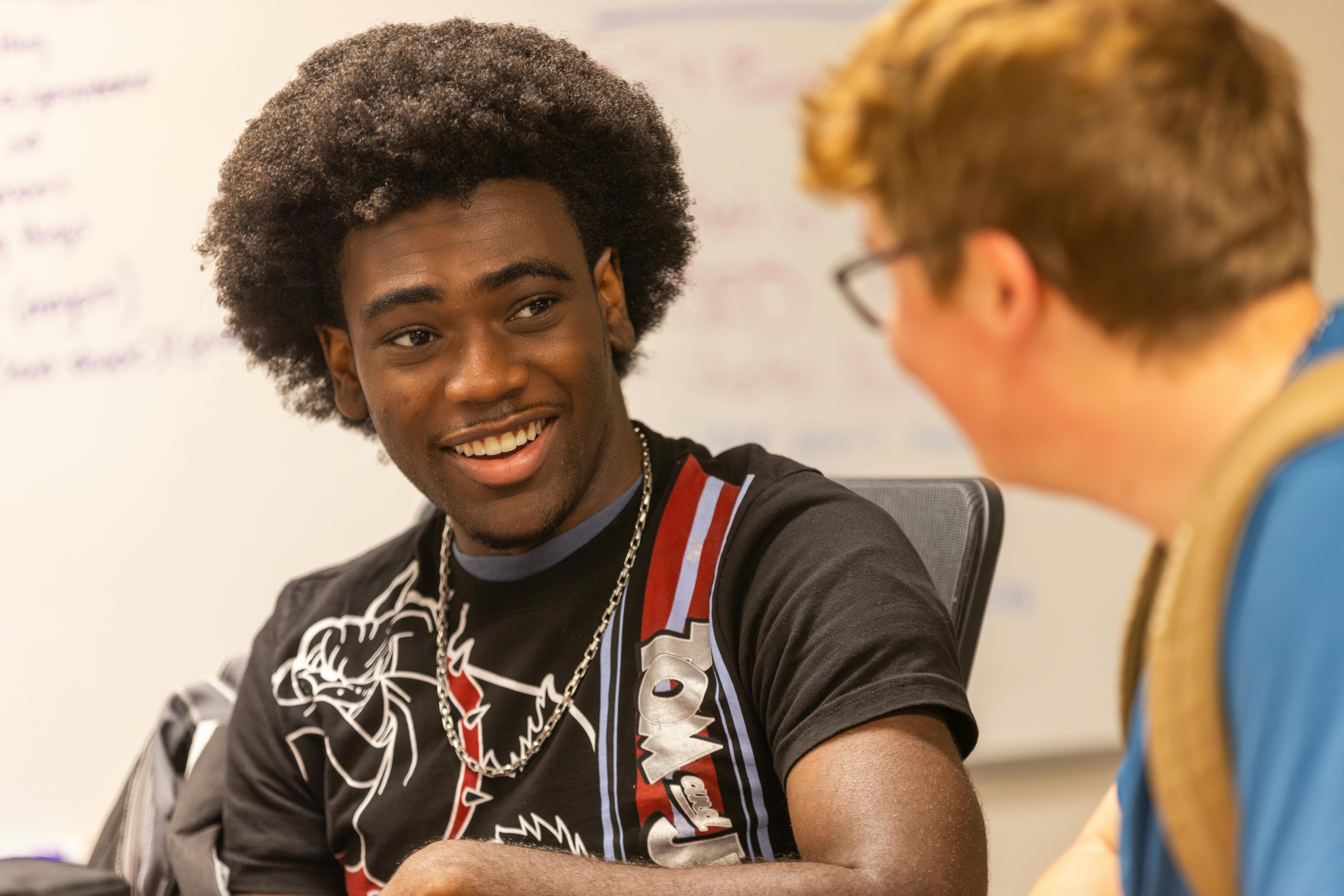 two male students talking in a SEMO classroom. 