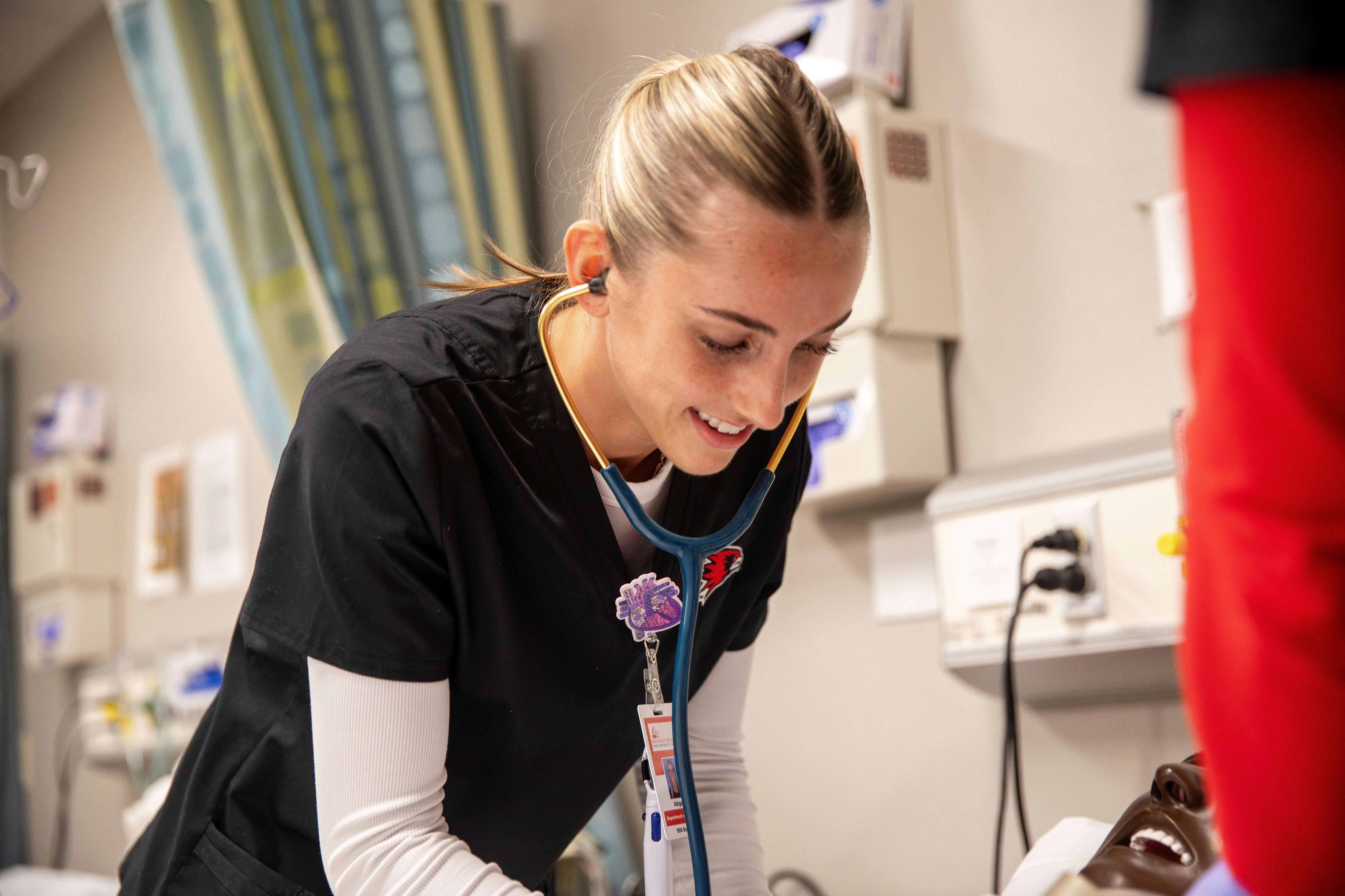 nursing student practicing nursing skill on a mannquin