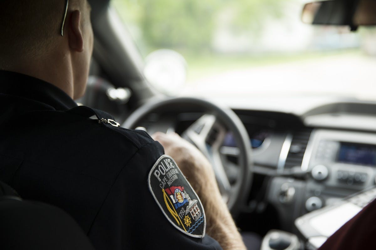 Image of a police officer driving a patrol car