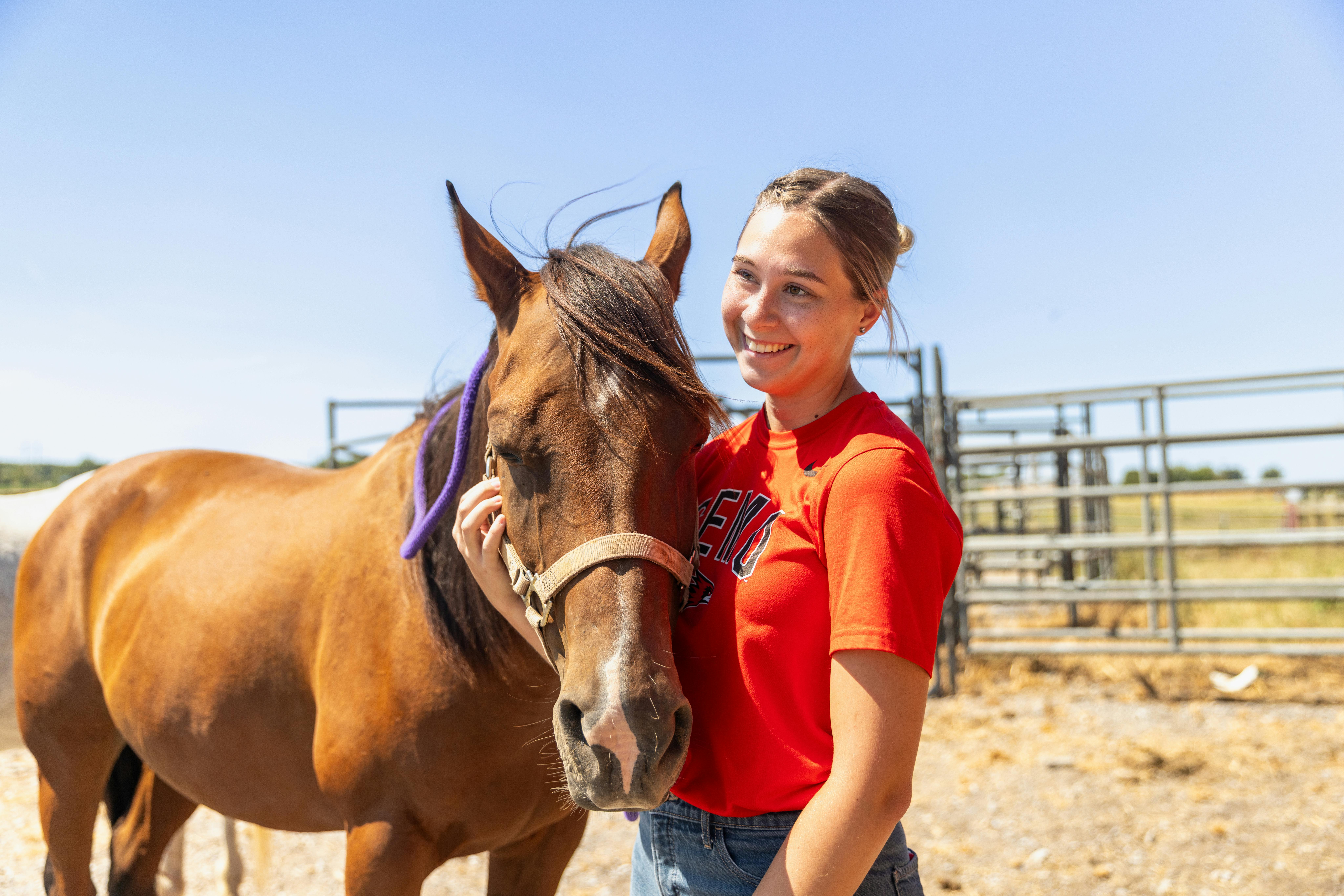 SEMO agriculture student, posing with a horse at the David M Barton Agriculture Research Center