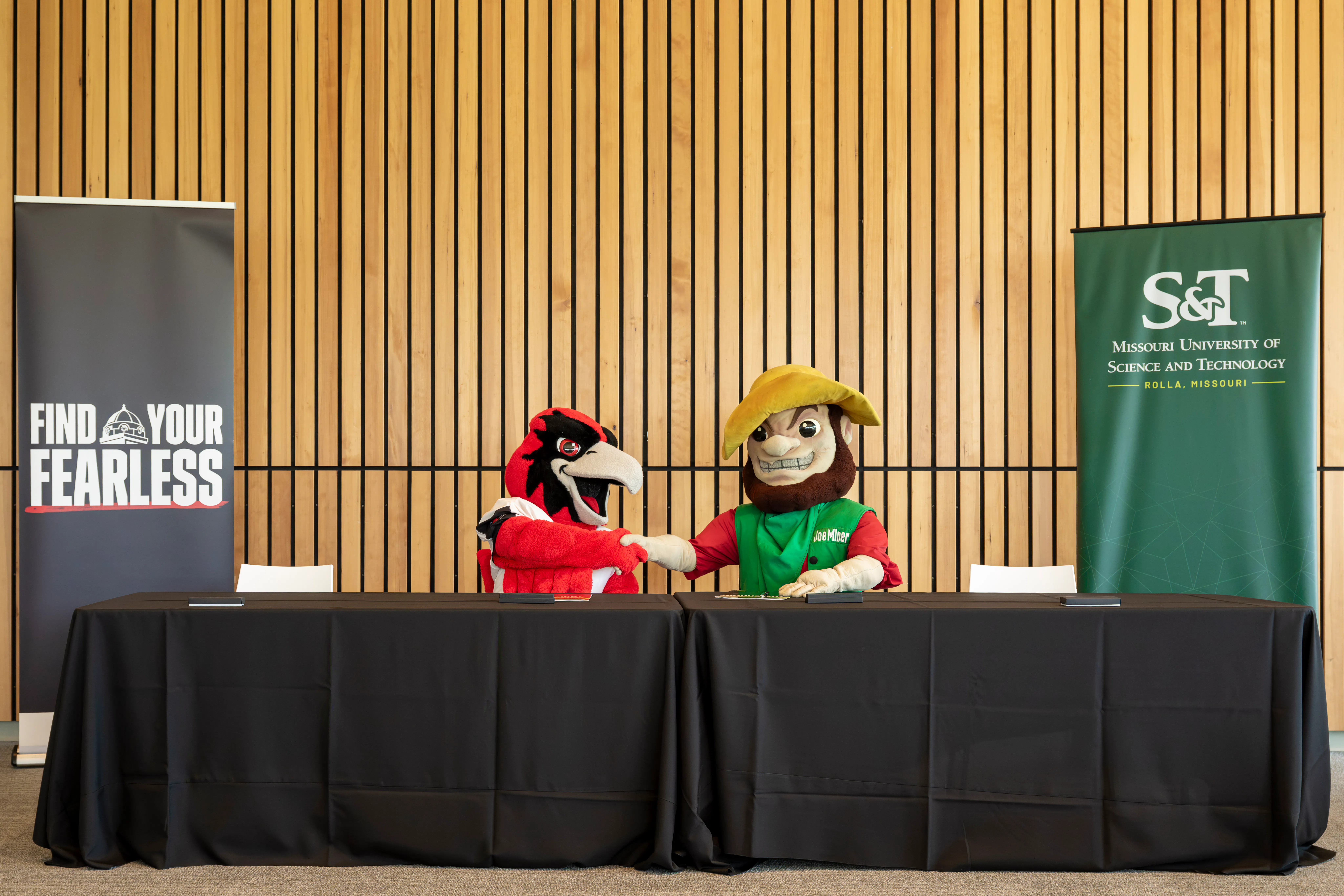 Rowdy and Joe Miner shake hands at the signing of the SEMO and Missouri S&T Partnership.