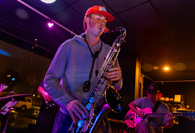 a student plays saxophone at a River Campus performance.