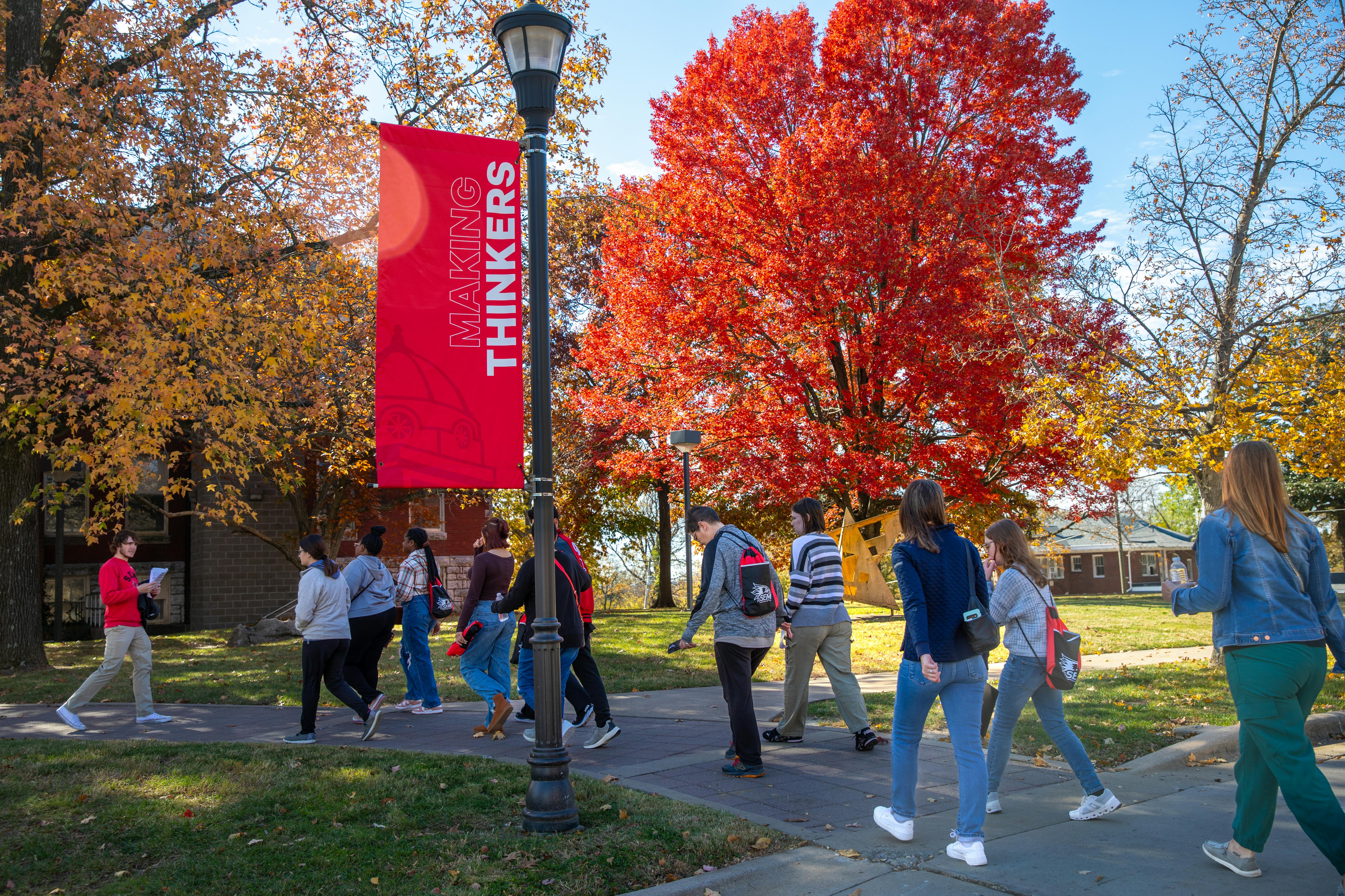 a hawk flock leader gives a campus tour to a group of students and their parents on show me day